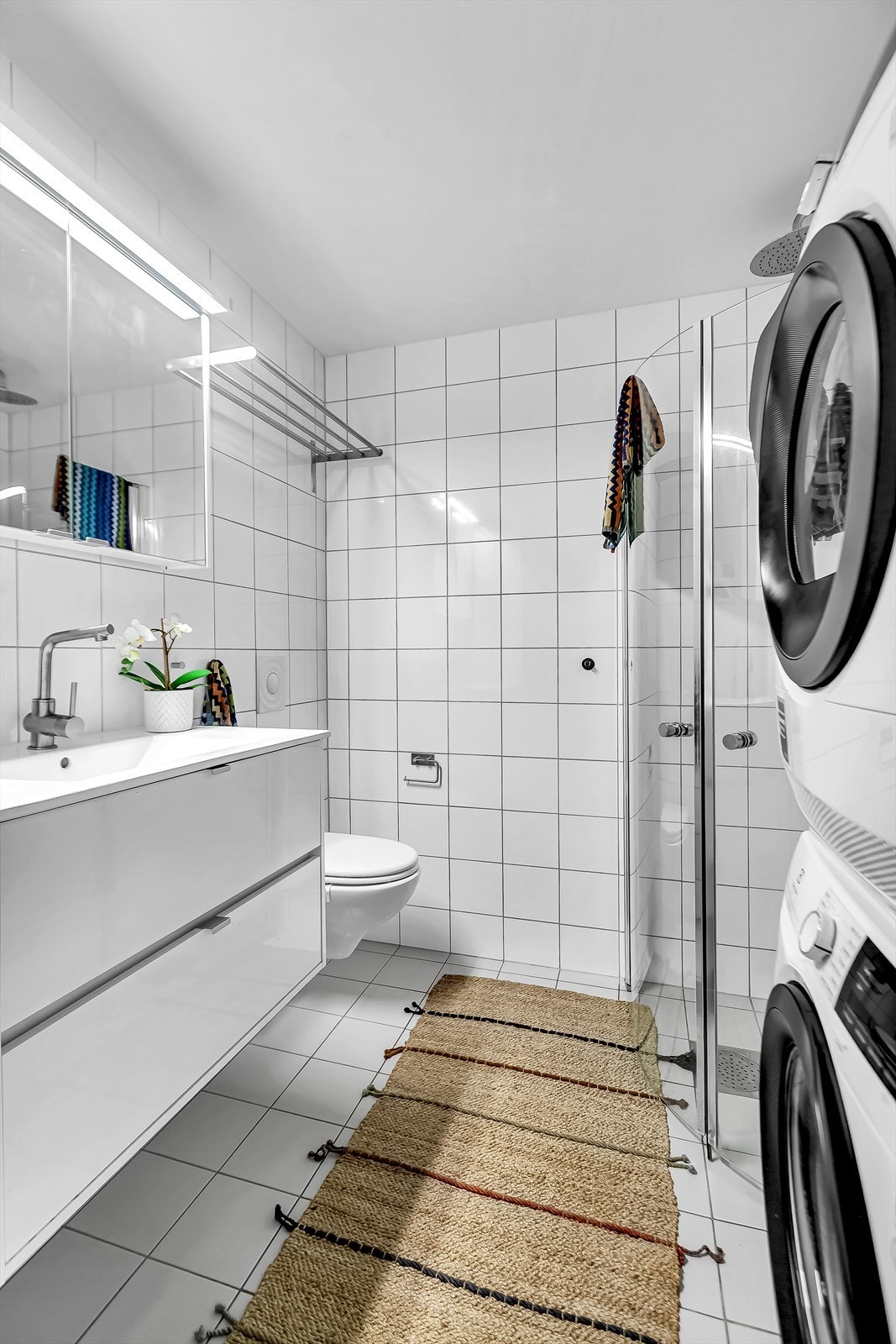 Pent flislagt bad med varme i gulv. Badet er innredet medservantskap med heldekkende servant og ethånds blandebateri, speilskap med integrert belysning over servant. Opplegg for full vaskesøyle Galleribilde