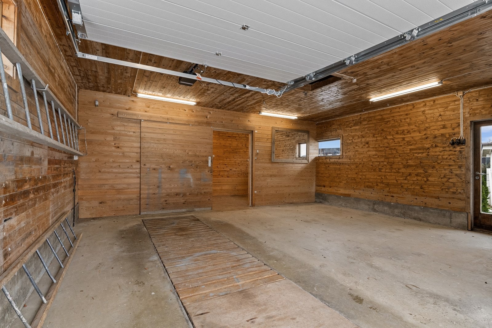 Romslig garasje med elektrisk port. Det er smøregrav i gulvet. Galleribilde