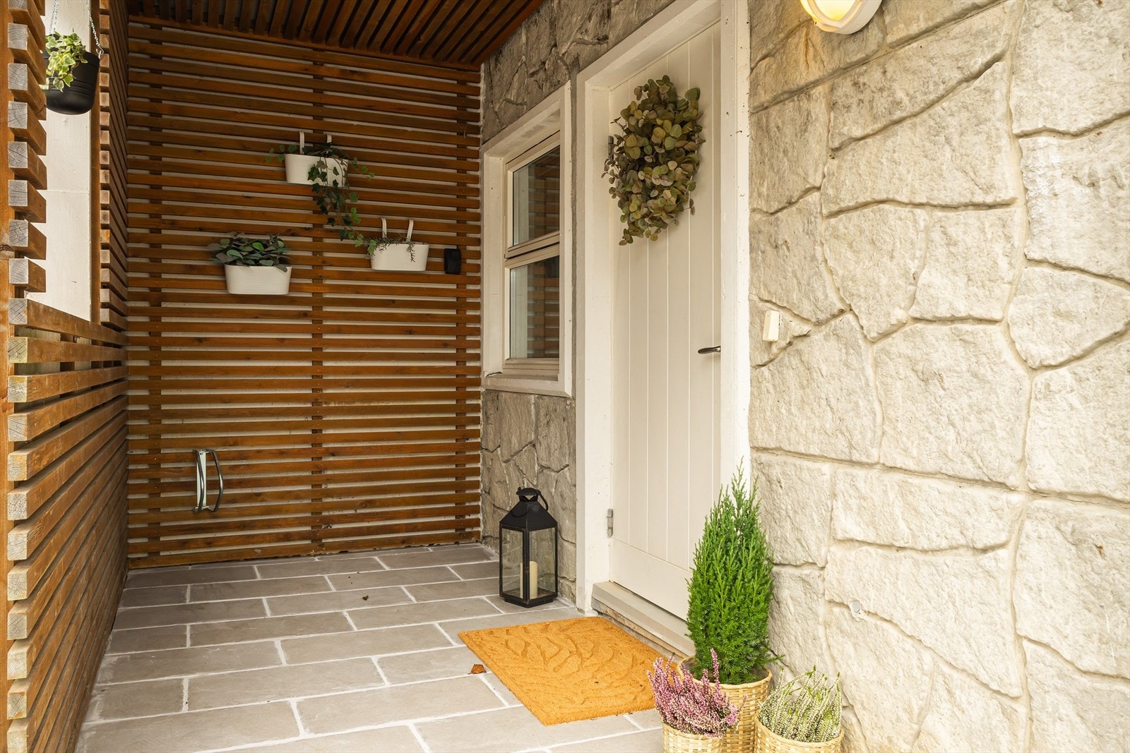 Inngangsparti med fliser og med dekorative detaljer som gir et innbydende førsteinntrykk. Galleribilde