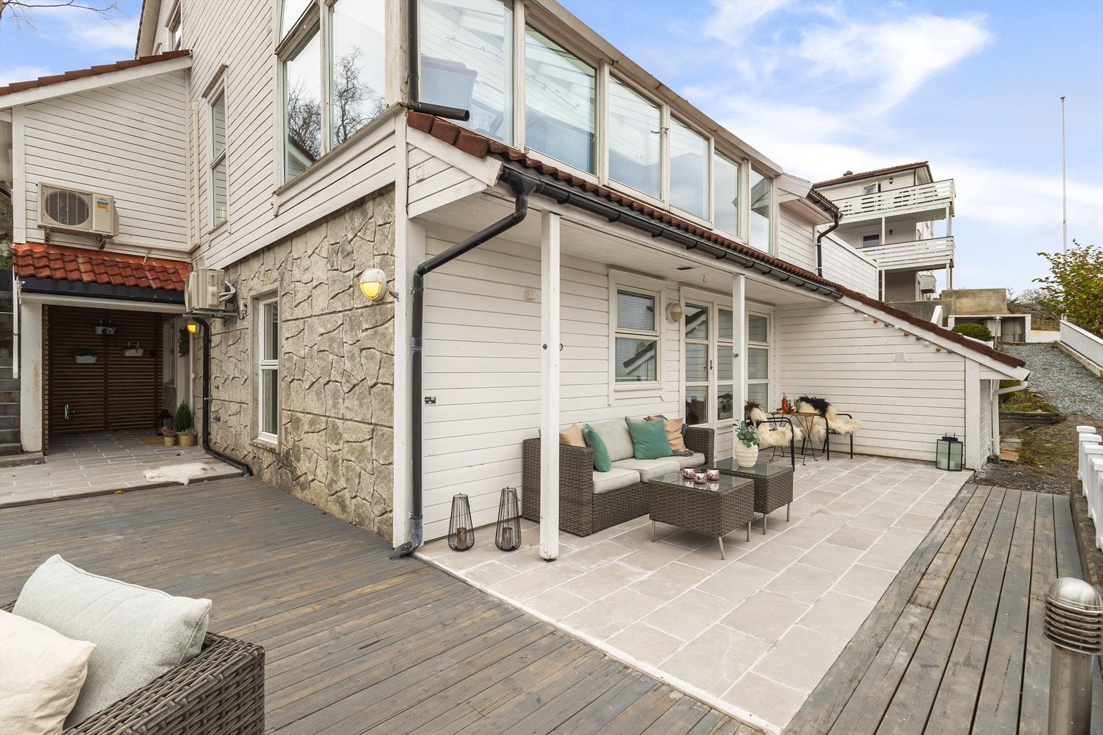 Videre er det adkomst til en romslig terrasse i tre som strekker seg rundt store deler av leiligheten. Galleribilde