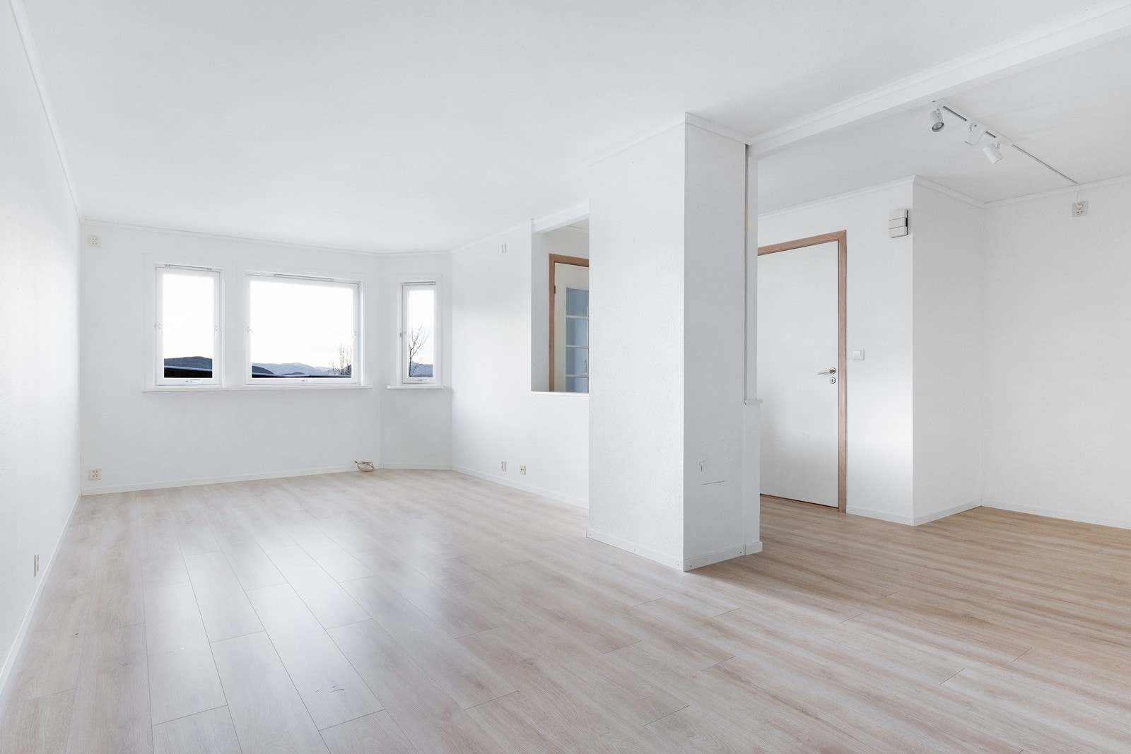 Lys og luftig stue med god plass til møblering av flere sittegrupper Galleribilde