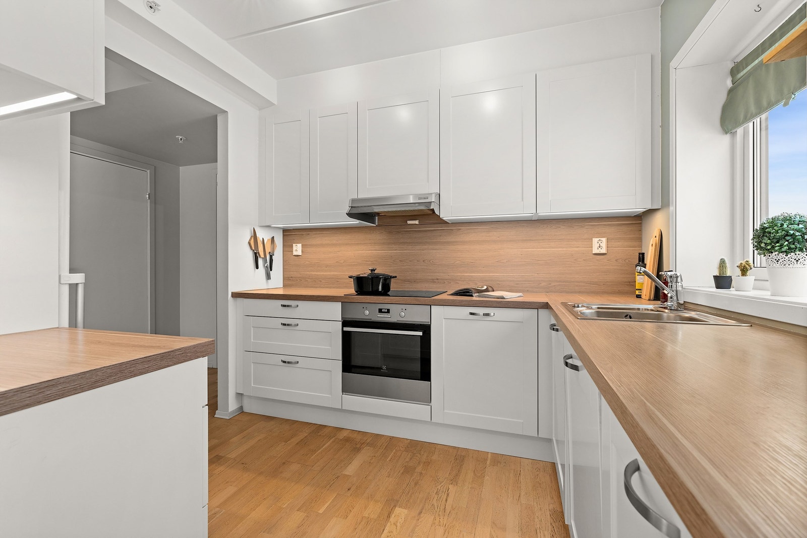 Fra spisestuen kommer man til kjøkkenet som har en delvis åpen løsning mot stue. Kjøkkeninnredning med hvite profilerte fronter samt laminert benkeplate. Galleribilde