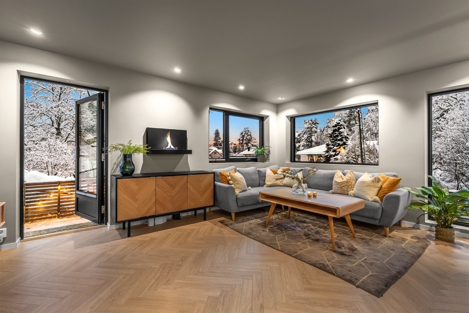 På gulvet er det flott fiskebens laminat, og på den ene veggen i stuen er det satt opp tenderflame peis Galleribilde