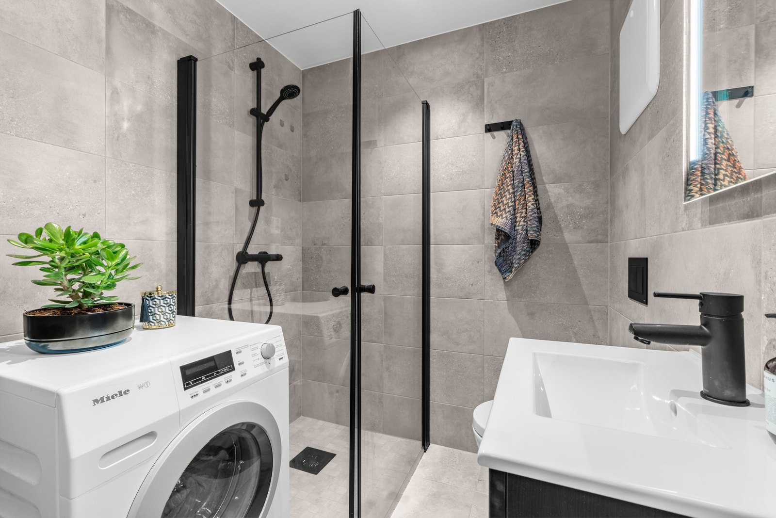 Her finner man også et pent, flislagt bad med varmekabler og opplegg for vaskemaskin og tørketrommel Galleribilde