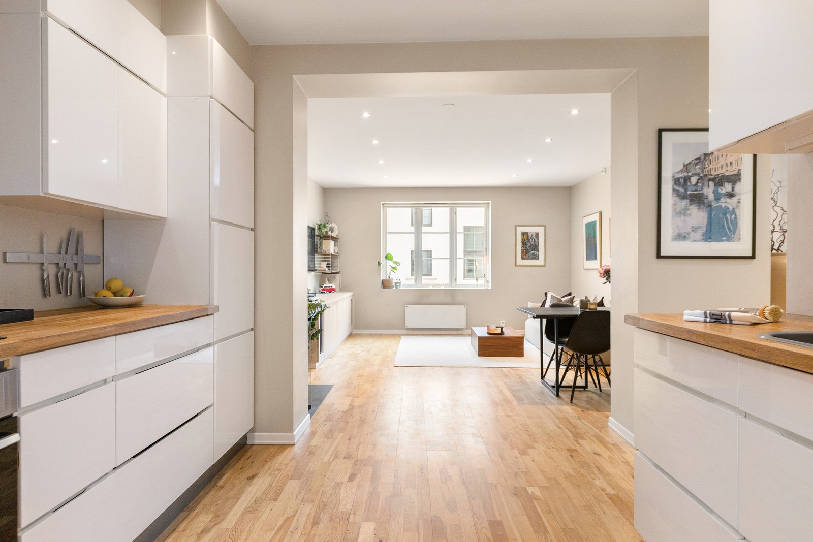 Moderne kjøkkeninnredning med glatte fronter og heltre benkeplate i et stilrent uttrykk Galleribilde