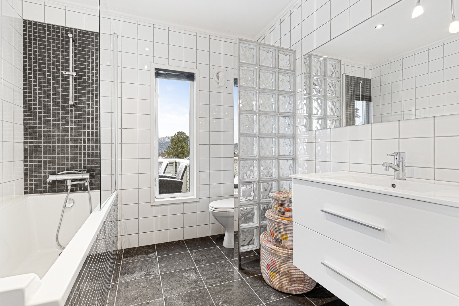 Pent, flislagt bad i 1.etg. som er innredet med toalett, plassbygget badekar med dusjmulighet og baderomsinnredning med servant og speil. Galleribilde