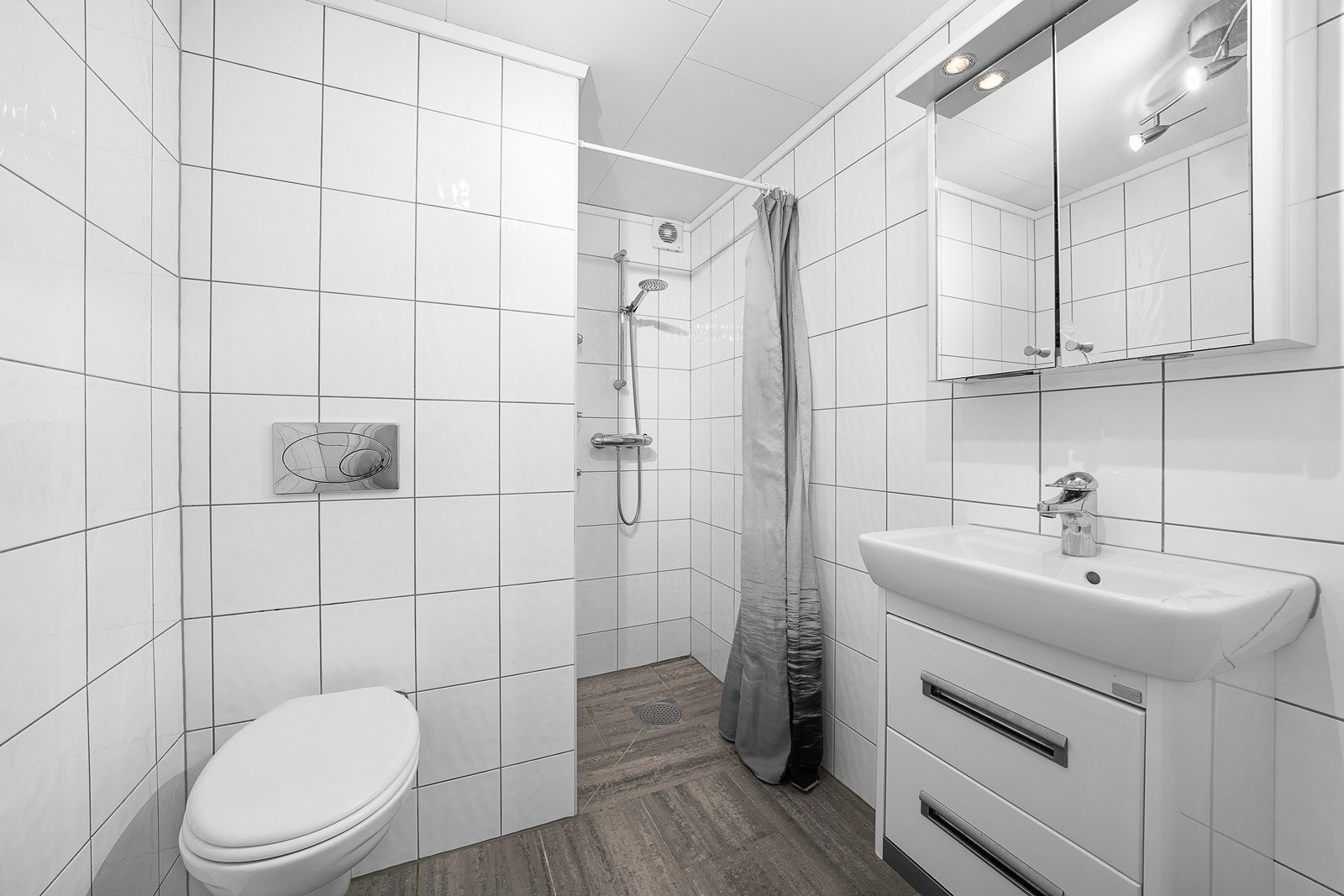 Badet i hybelen en har dusjnisje, en veggmontert toalett, servantskap og gulvvarme. Galleribilde