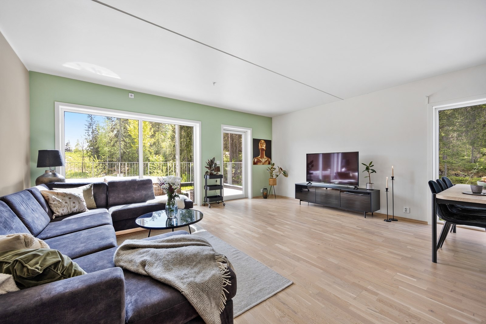 Leiligheten har en åpen stue- og kjøkkenløsning med store vindusflater på flere vegger Galleribilde