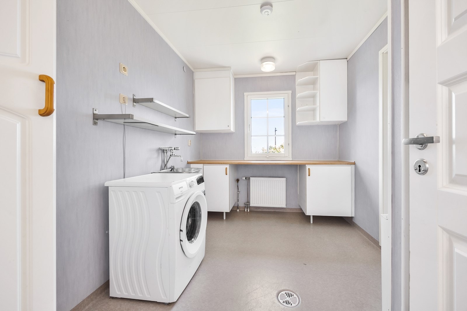 Vaskerommet er praktisk innredet med benkeplate, utslagskum og egen utgangsdør. Galleribilde