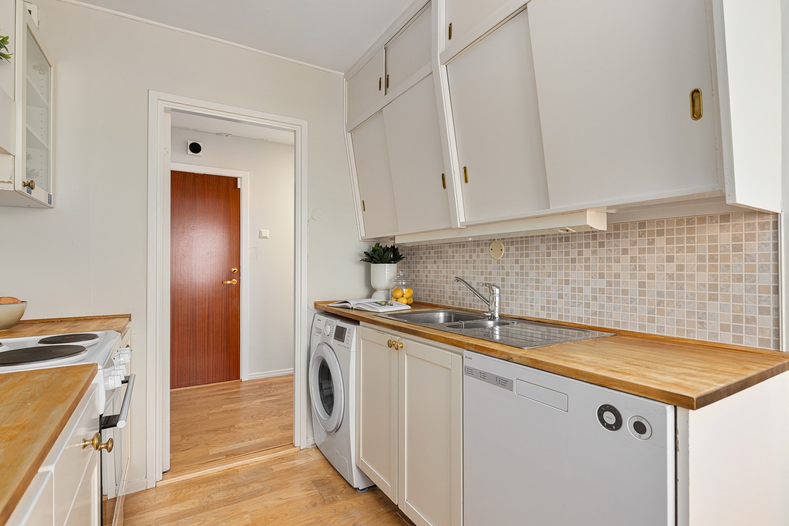 Kjøkkenet er godt utnyttet med skap- og benkeplass. Ønsker man mer plass, er det mulig å "trekke" kjøkkenbenken rundt hjørnet mot stuen Galleribilde