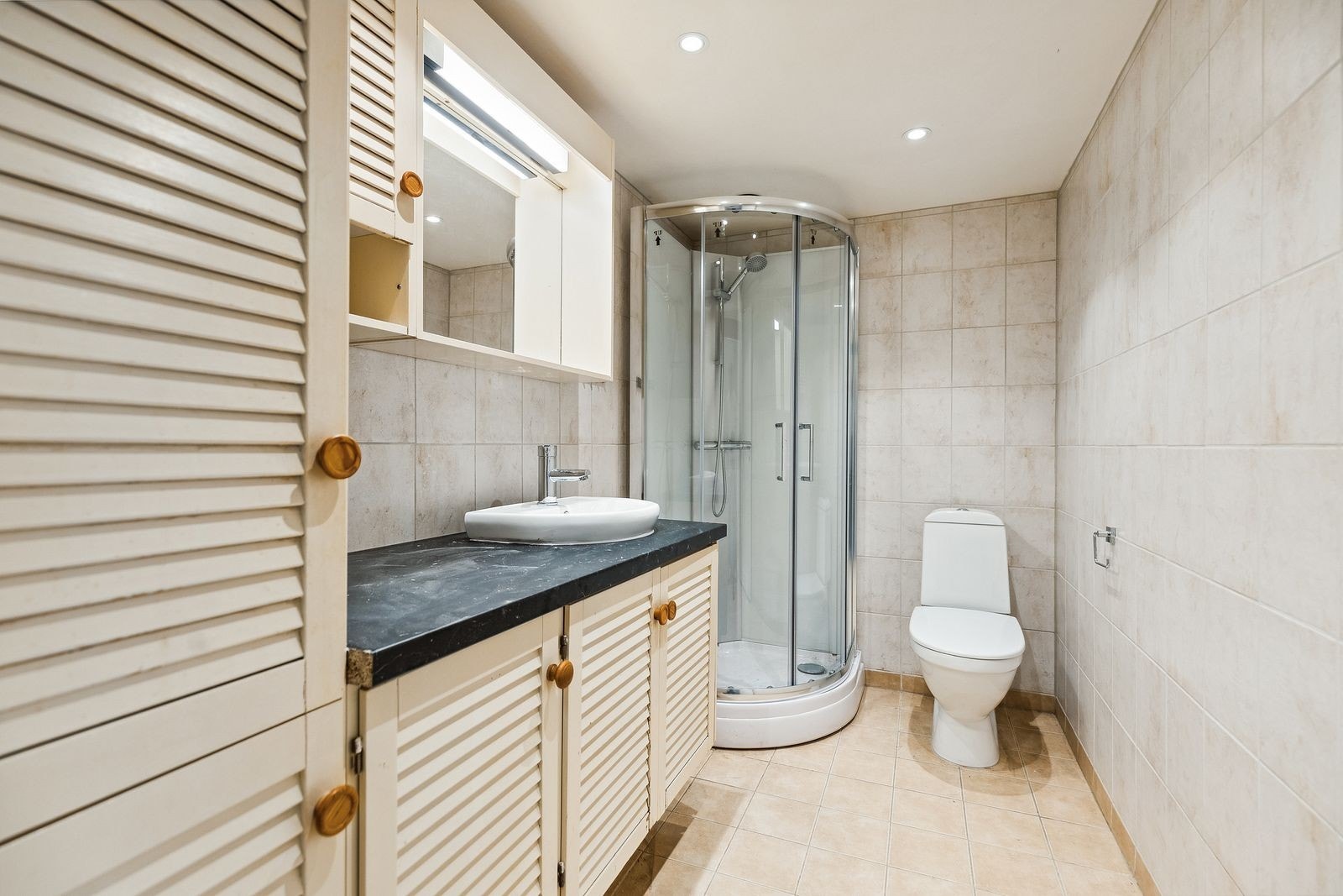 Bad med wc, dusj og servant med godt med oppbevaring rundt. Galleribilde