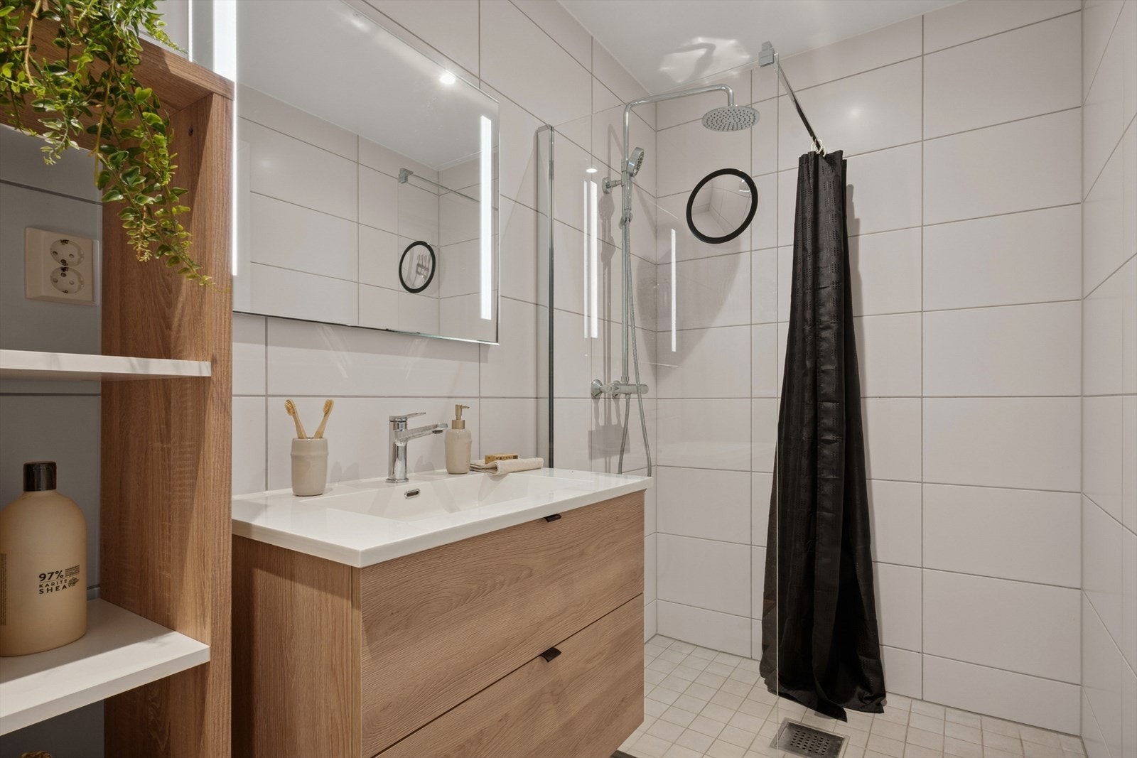 Badene er innredet med stilrene baderomsmøbler med heldekkende servant, eikfargede fronter og speil med belysning. Galleribilde