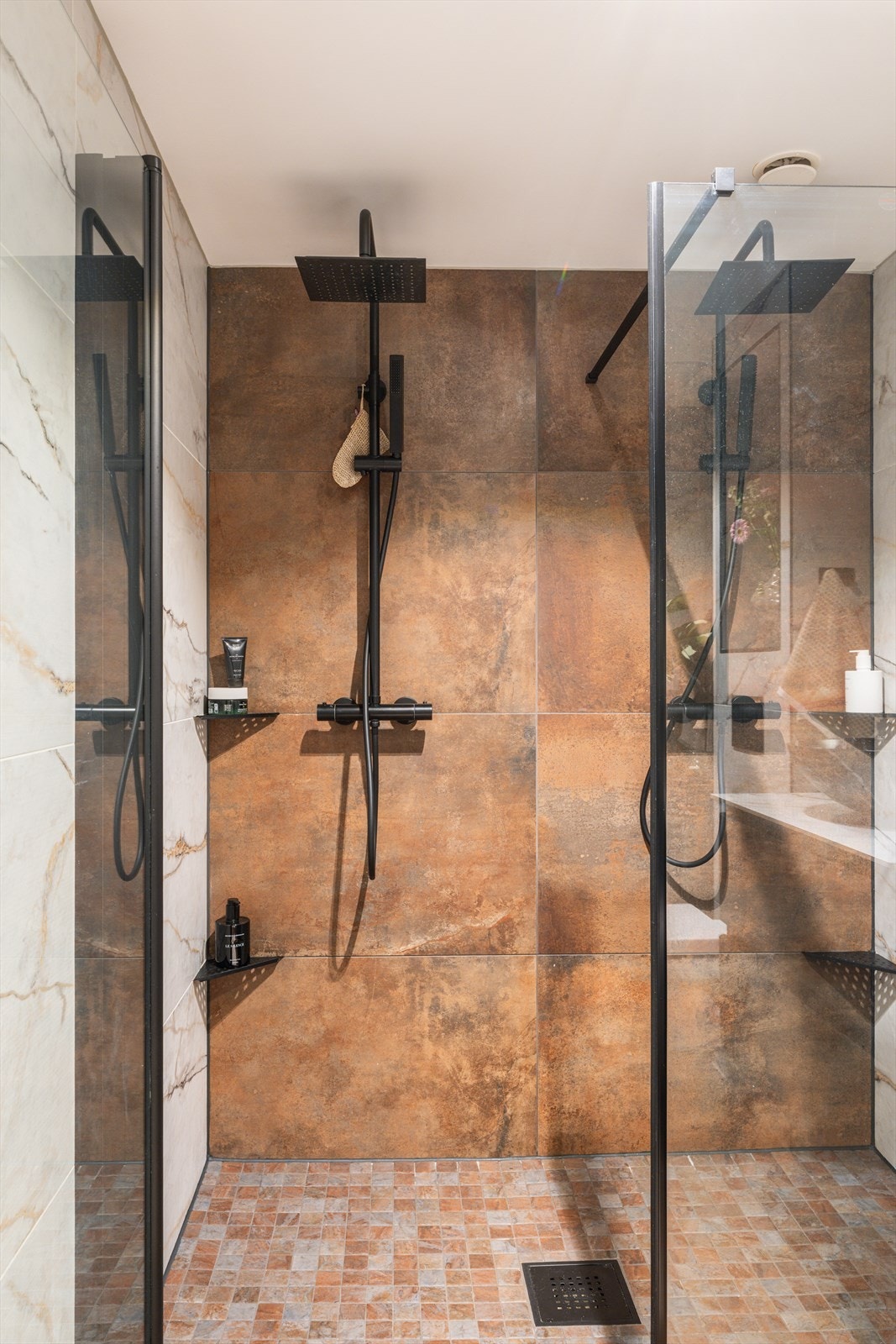 Eksklusiv dusjløsning med dobbel regndusj og moderne sort armatur. Galleribilde