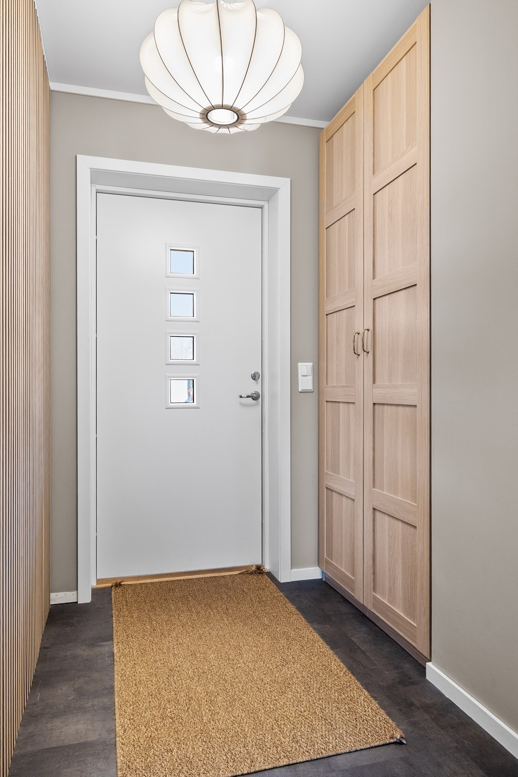 Entréen gir et ryddig og praktisk førsteinntrykk med fliser på gulv og godt med garderobeplass. Galleribilde