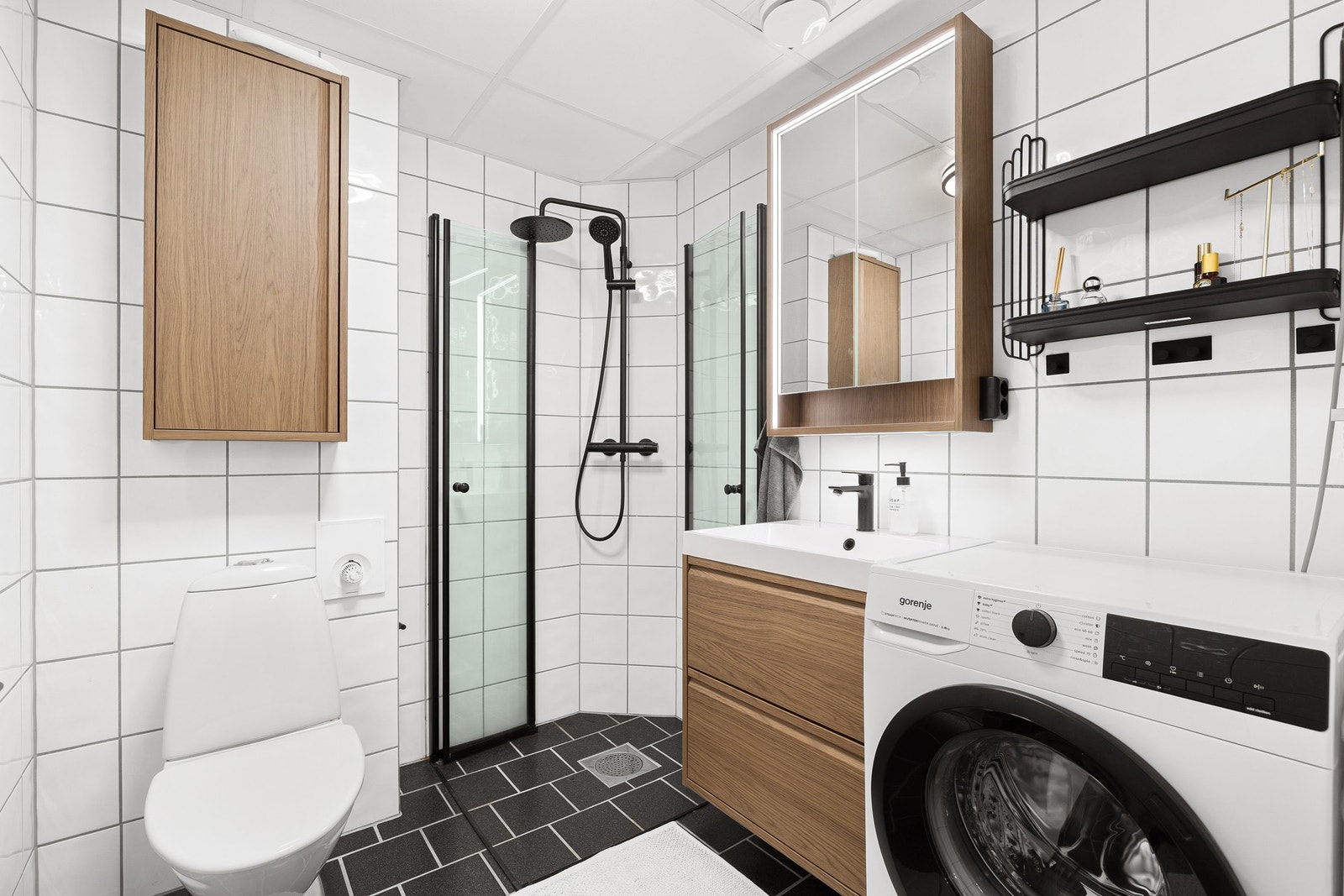 Badet fremstår innbydende og praktisk, med oppdatert innredning, gulvvarme og opplegg for vaskemaskin Galleribilde