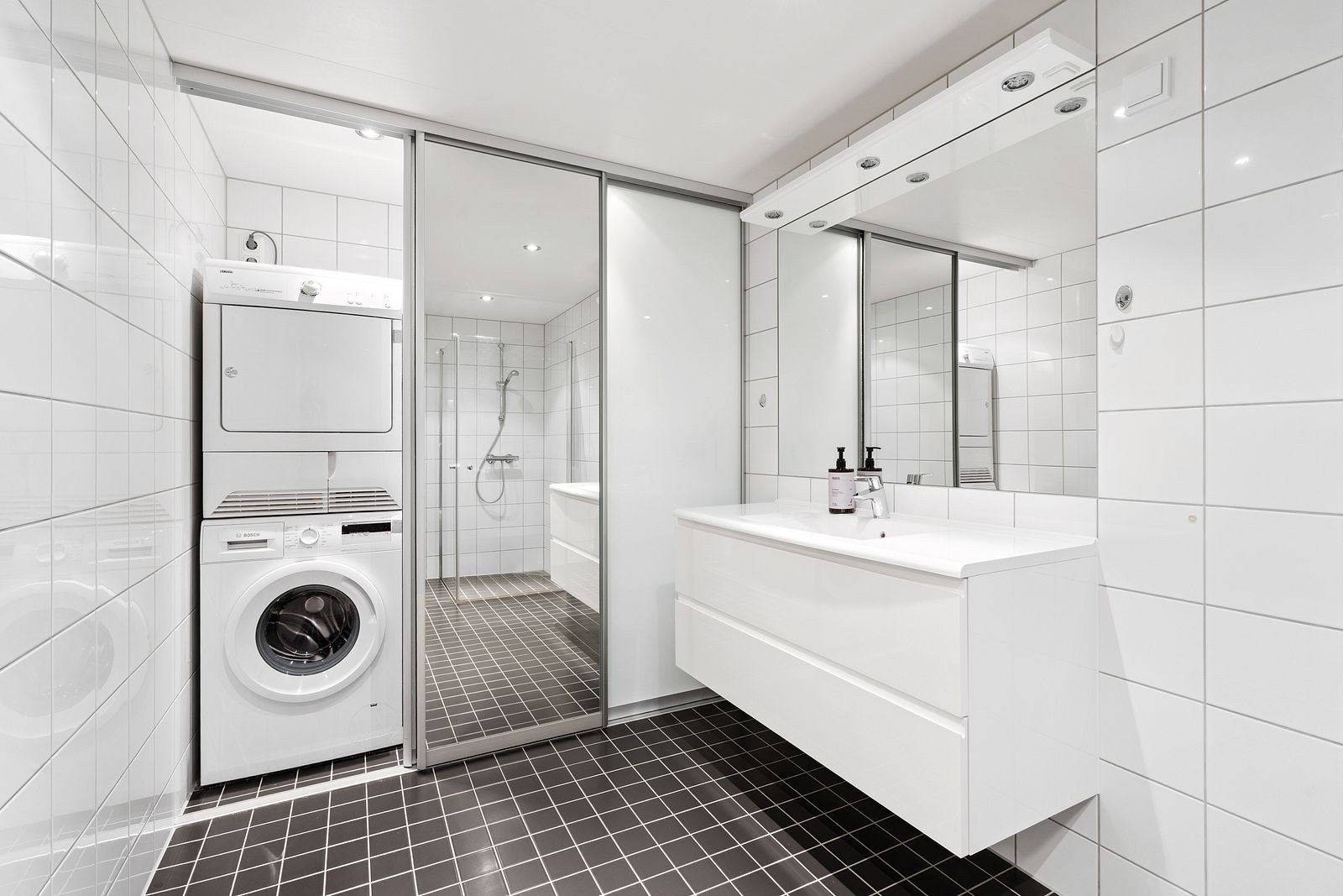 Vaskeromsonen er etablert bak en takhøy skyvedørsgarderobe der ett av dørene har helspeil. Det er også skyllekum i vaskeromsonen. Det er spotter i tak på baderommet. Galleribilde