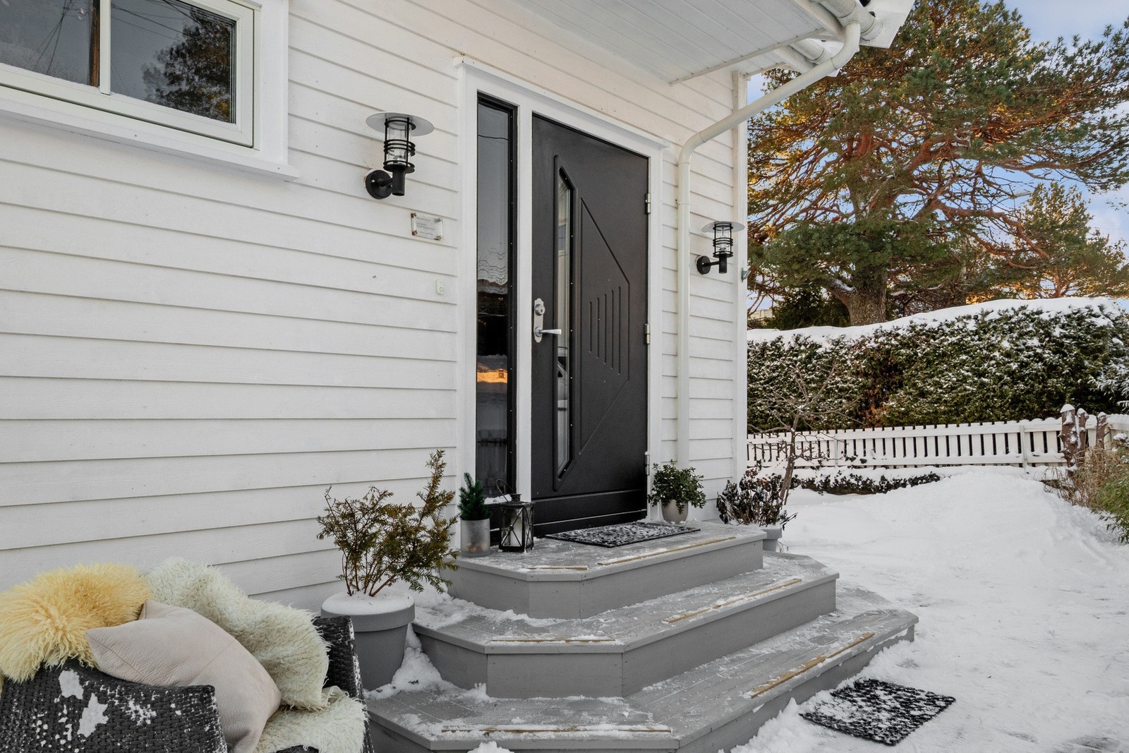 Inngangspartiet er overbygd og utstyrt med belysning og ringeklokke. I Galleribilde