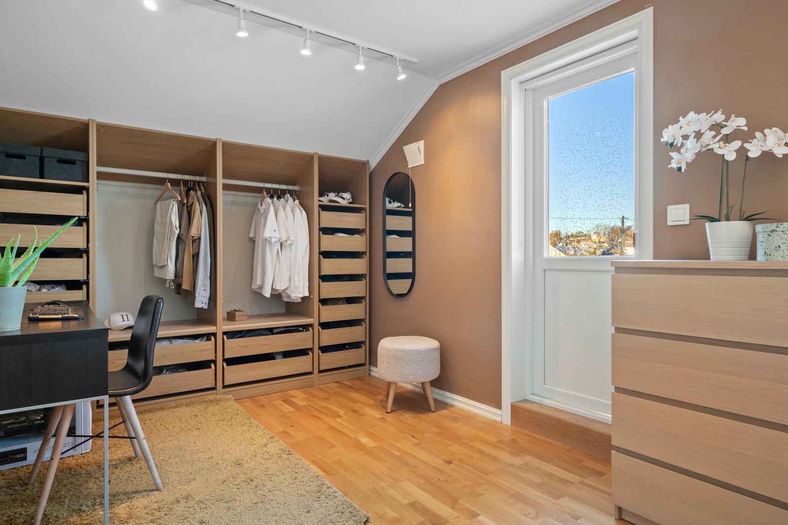 Langs den ene kneveggen er det etablert et åpent garderobesystem med skuffer, hyller og stenger for oppheng. Galleribilde