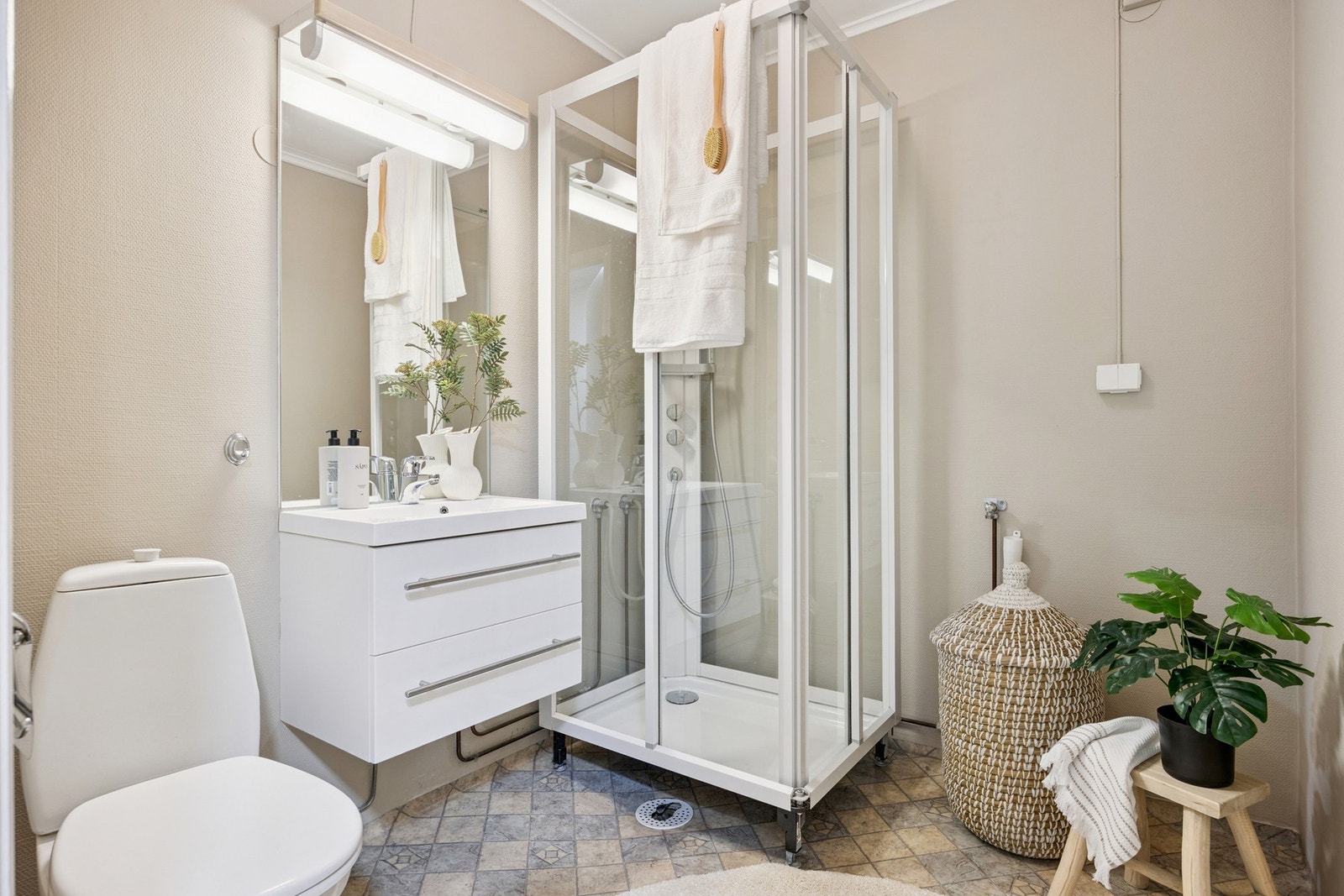 Funksjonelt bad med dusjkabinett, servantinnredning, speil med overlys og opplegg for vaskemaskin. Galleribilde