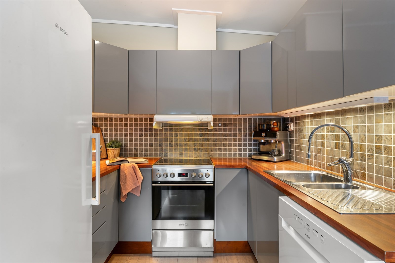 Kjøkkeninnredning med slette fronter og laminert benkeplate. Galleribilde