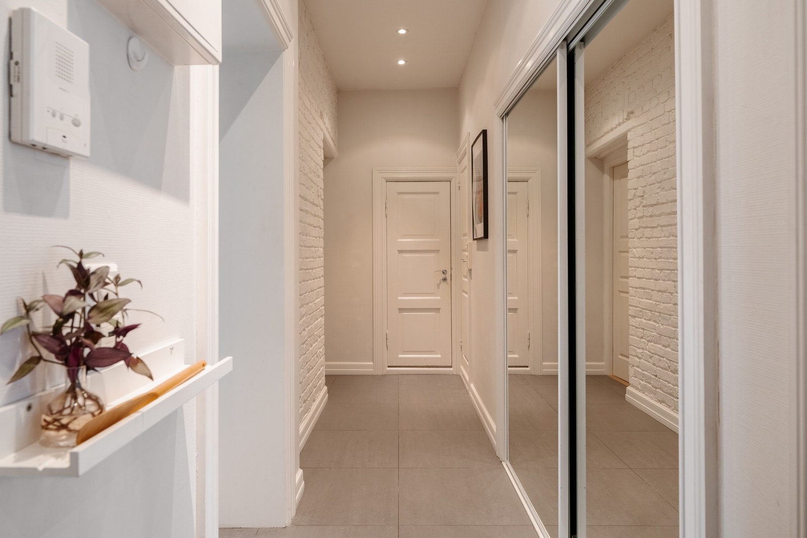 Boligen har en hyggelig gang med flislagt gulv, malt teglsteinsvegg og downlights i himlingen. Galleribilde