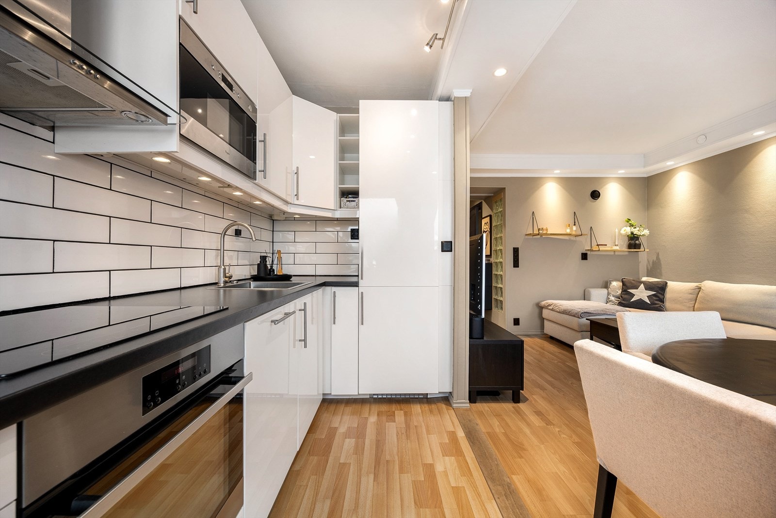 Leiligheten har en åpen stue- og kjøkkenløsning som utgjør boligens sosiale sone Galleribilde