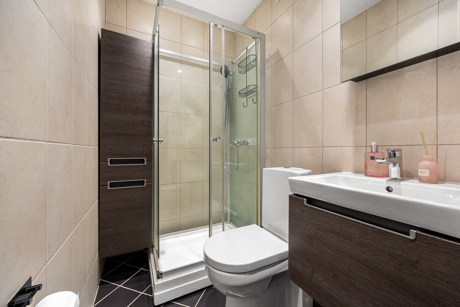 Badet har flislagte overflater, dusjkabinett og oppvarming via radiator Galleribilde