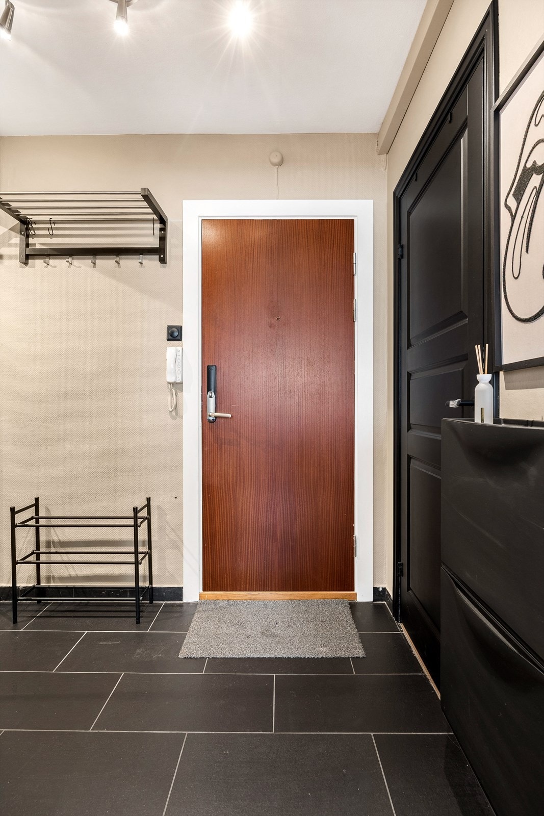 Entréen har flislagt gulv og en brann- og lydklassifisert inngangsdør Galleribilde