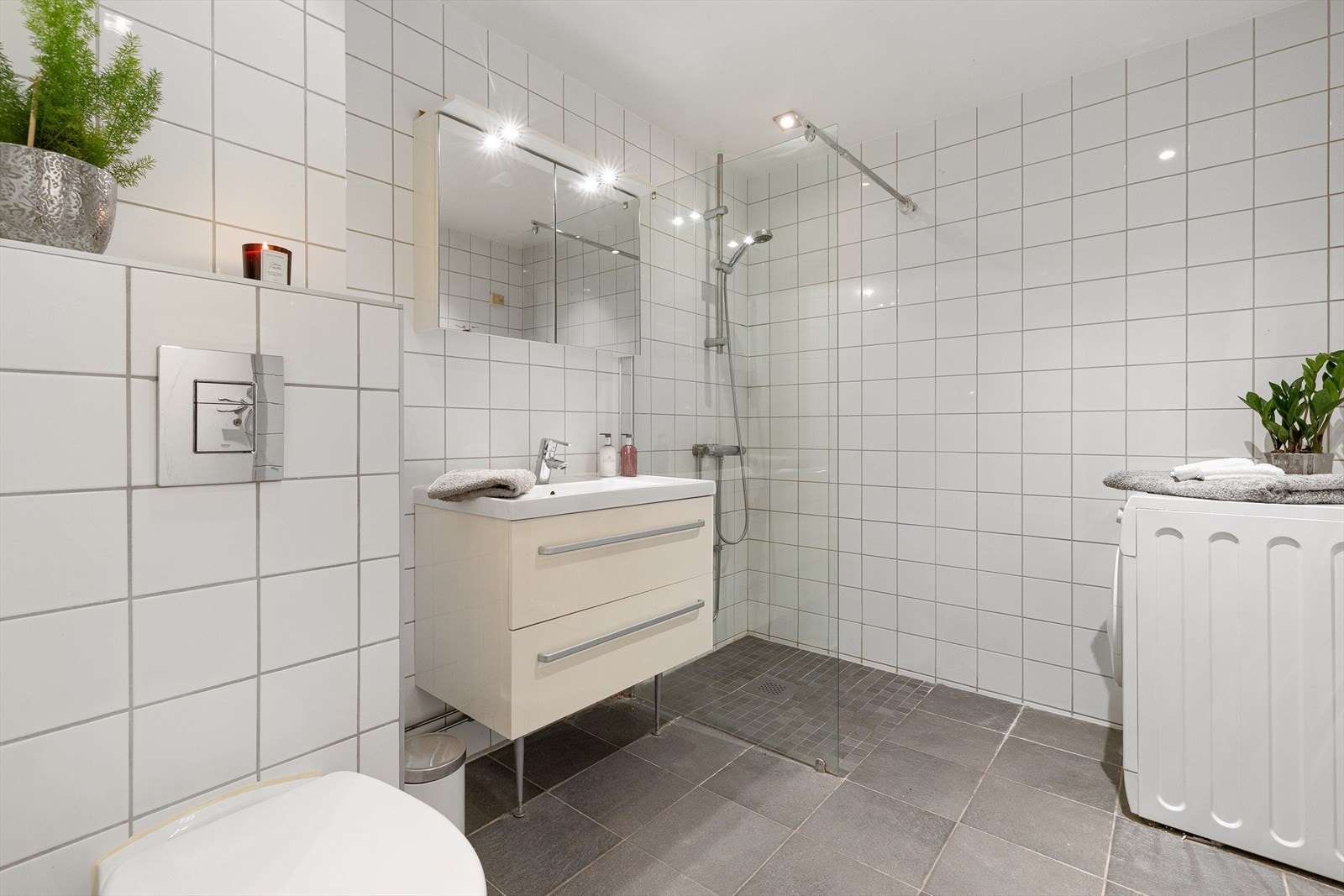 Romslig bad fra byggeår med flislagte overflater, behagelig gulvvarme og opplegg for vaskemaskin. Galleribilde