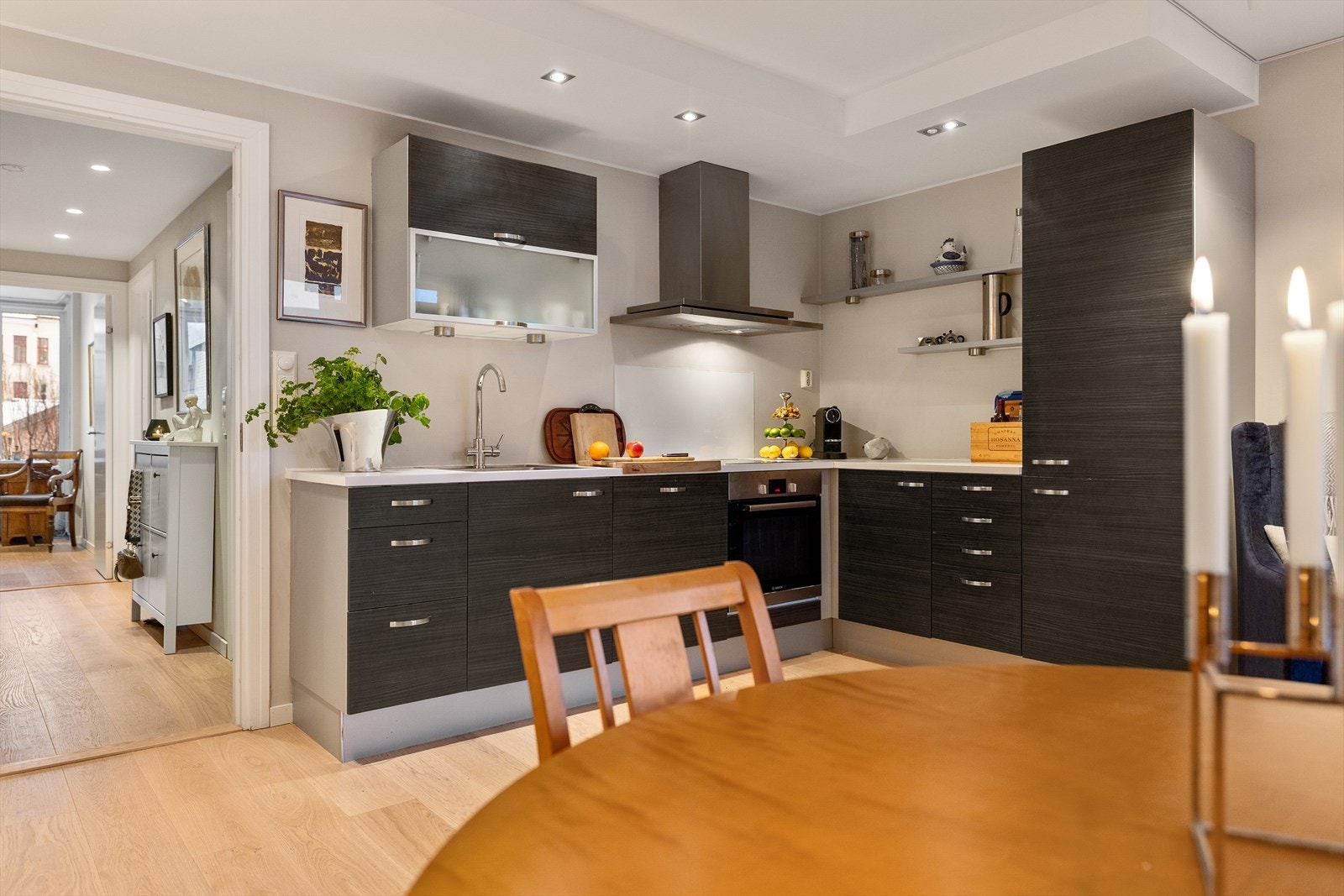 Pent og arealeffektivt kjøkken fra 2011. Innredning med mørke, glatte skapfronter og benkeplate i laminat. Galleribilde