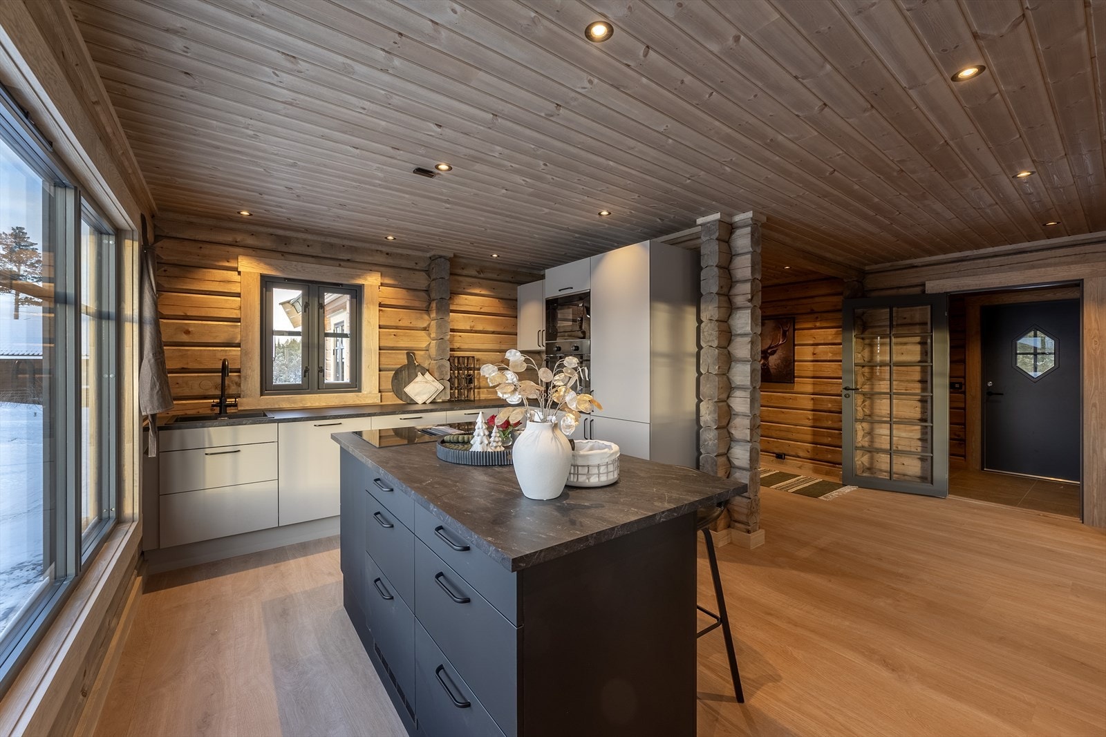 Den åpne hallen knytter sammen stua og kjøkkenet - Kjøkkenet har innredning med integrerte hvitevarer Galleribilde