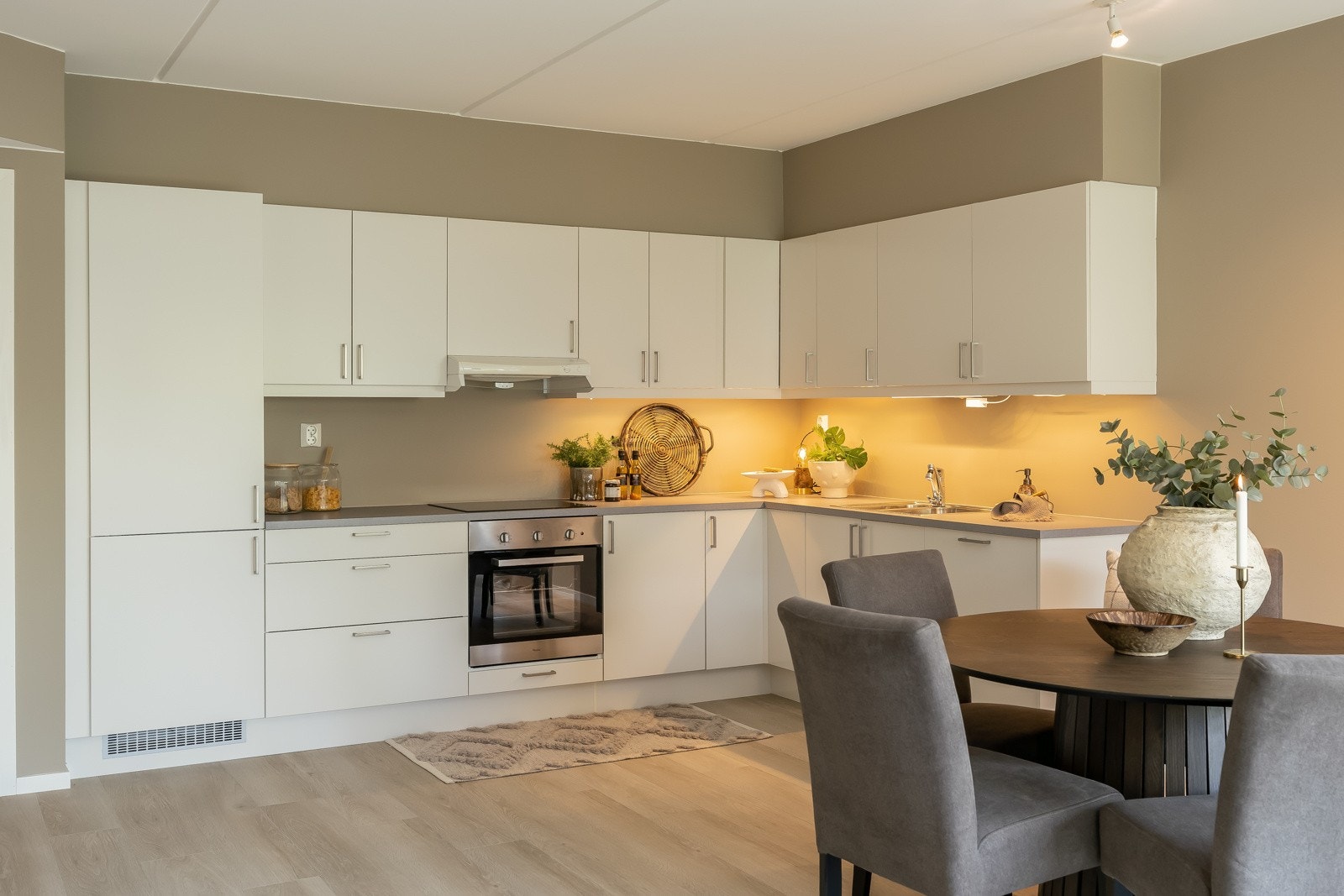 Du finner moderne hvitevarer som kjøleskap, oppvaskmaskin og komfyr, integrert i innredningen for en helhetlig og ryddig look. Galleribilde