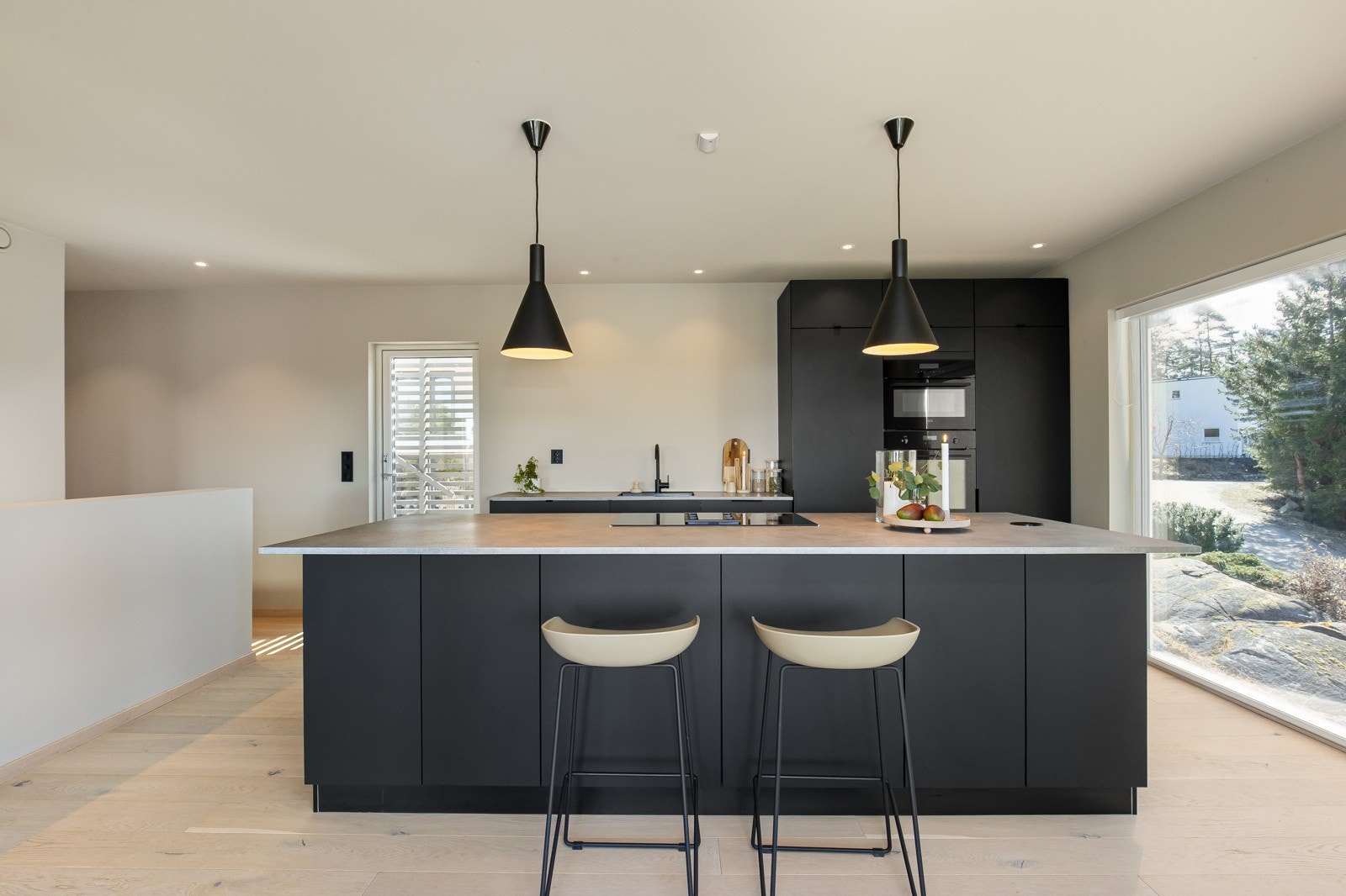 Åpen kjøkkenløsning med sort Kvik innredning og integrerte hvitevarer. Kjøkkenet har godt med skuffer og skap, kjøkkenøy med plass til barstoler samt gode arbeidsflater til hobbykokkens store glede Galleribilde