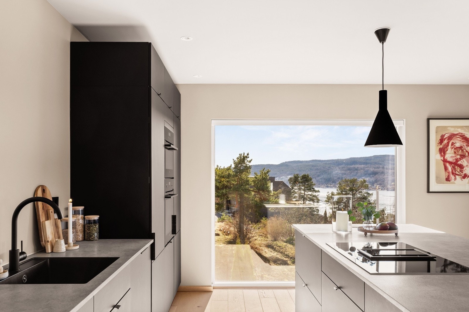 Åpen kjøkkenløsning med sort Kvik innredning og integrerte hvitevarer. Kjøkkenet har godt med skuffer og skap, kjøkkenøy med plass til barstoler samt gode arbeidsflater til hobbykokkens store glede Galleribilde