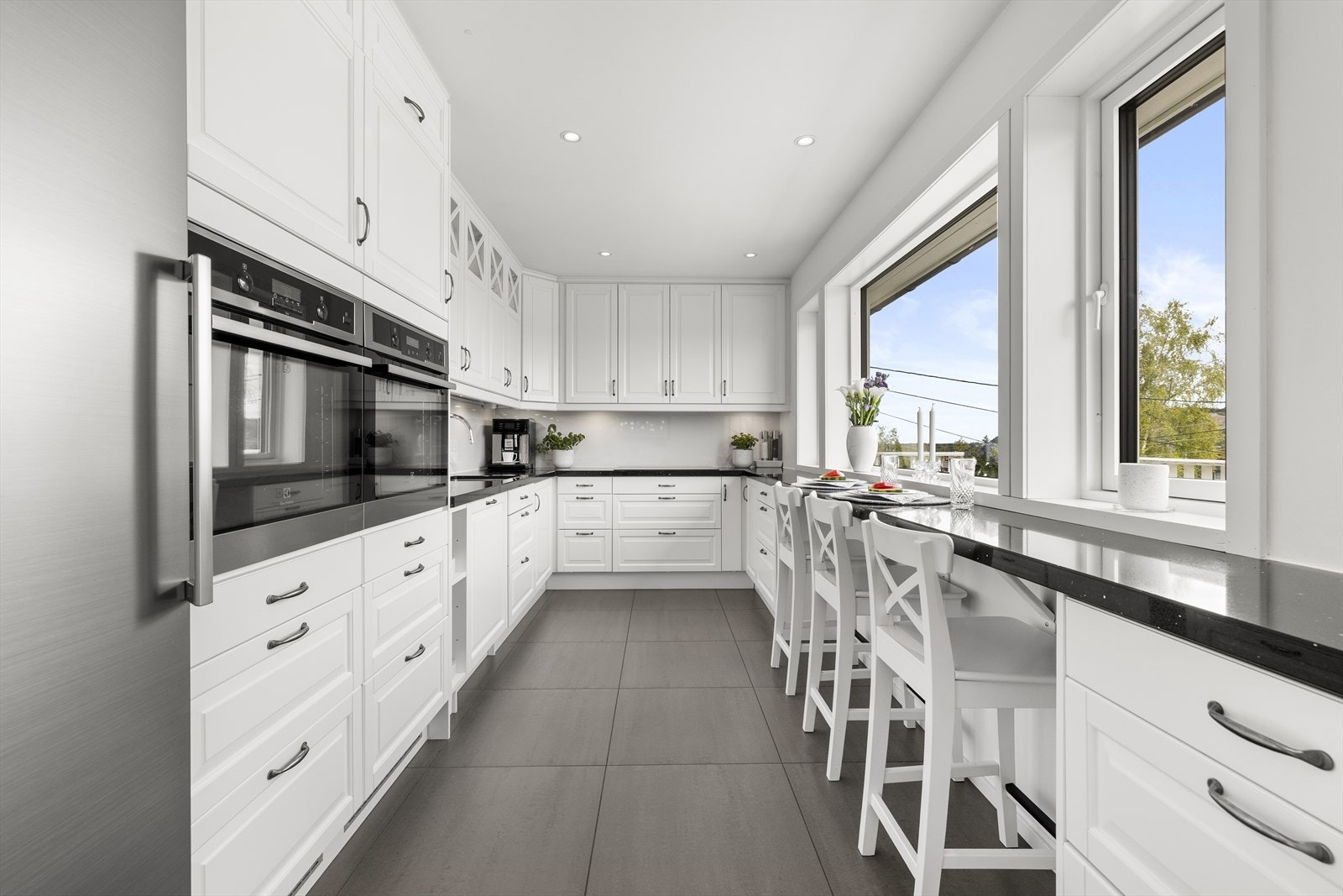 Kjøkkenet har en praktisk utforming med detaljer som takhøye overskap, spotbelysning og belysning under overskap. Galleribilde