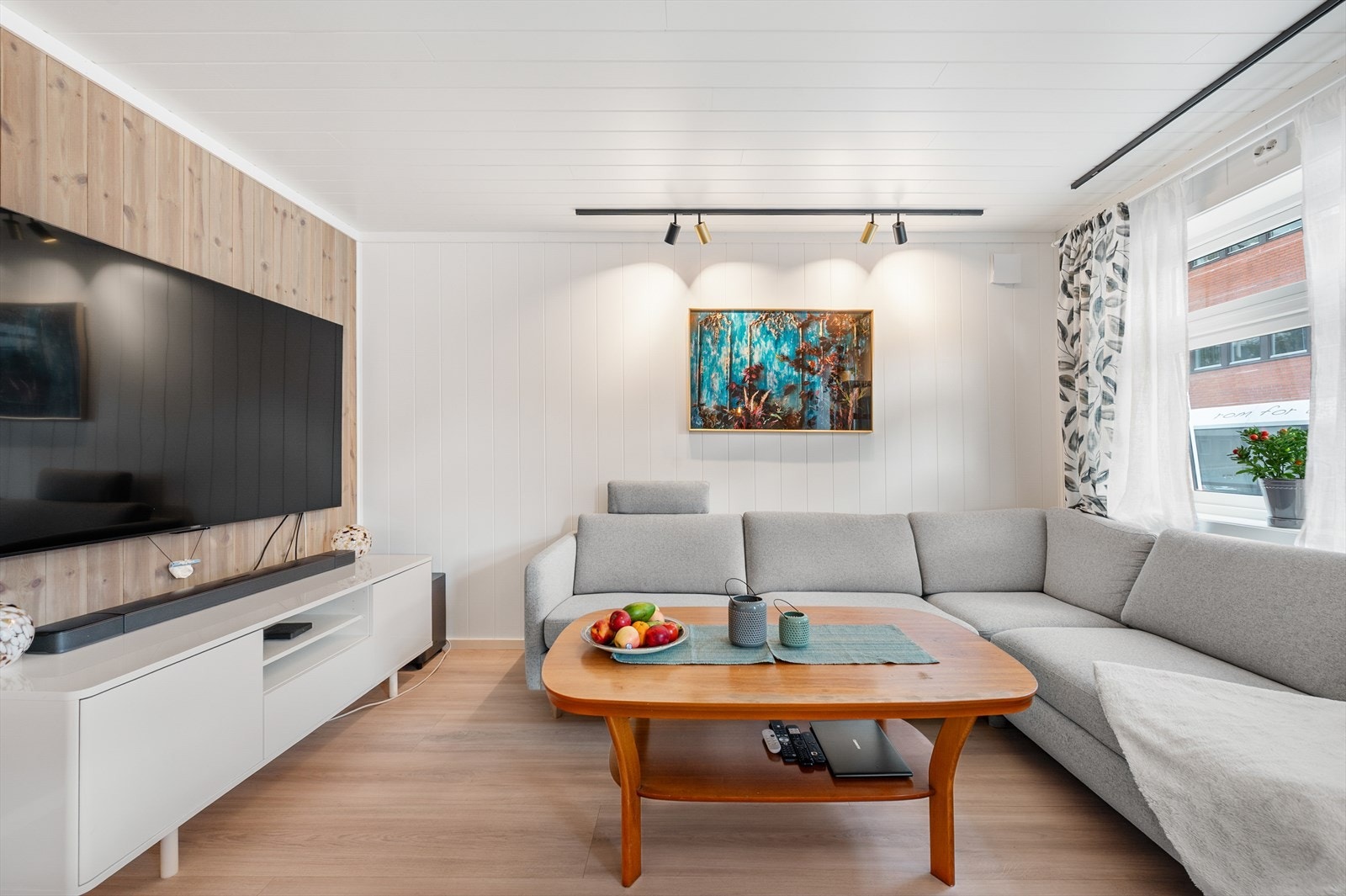 Vegger med en kombinasjon av lyst trepanel og malte flater gir rommet en lun karakter. Galleribilde