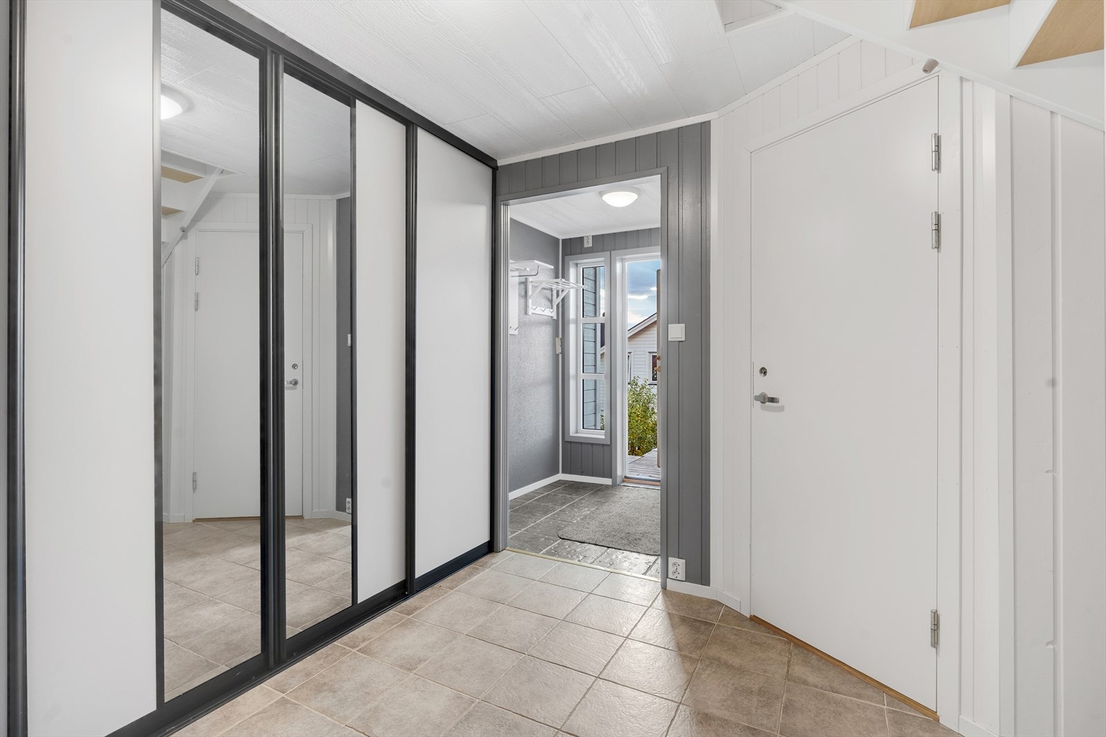 Flislagt entre, med romslig skyvedørsgarderobe. Galleribilde