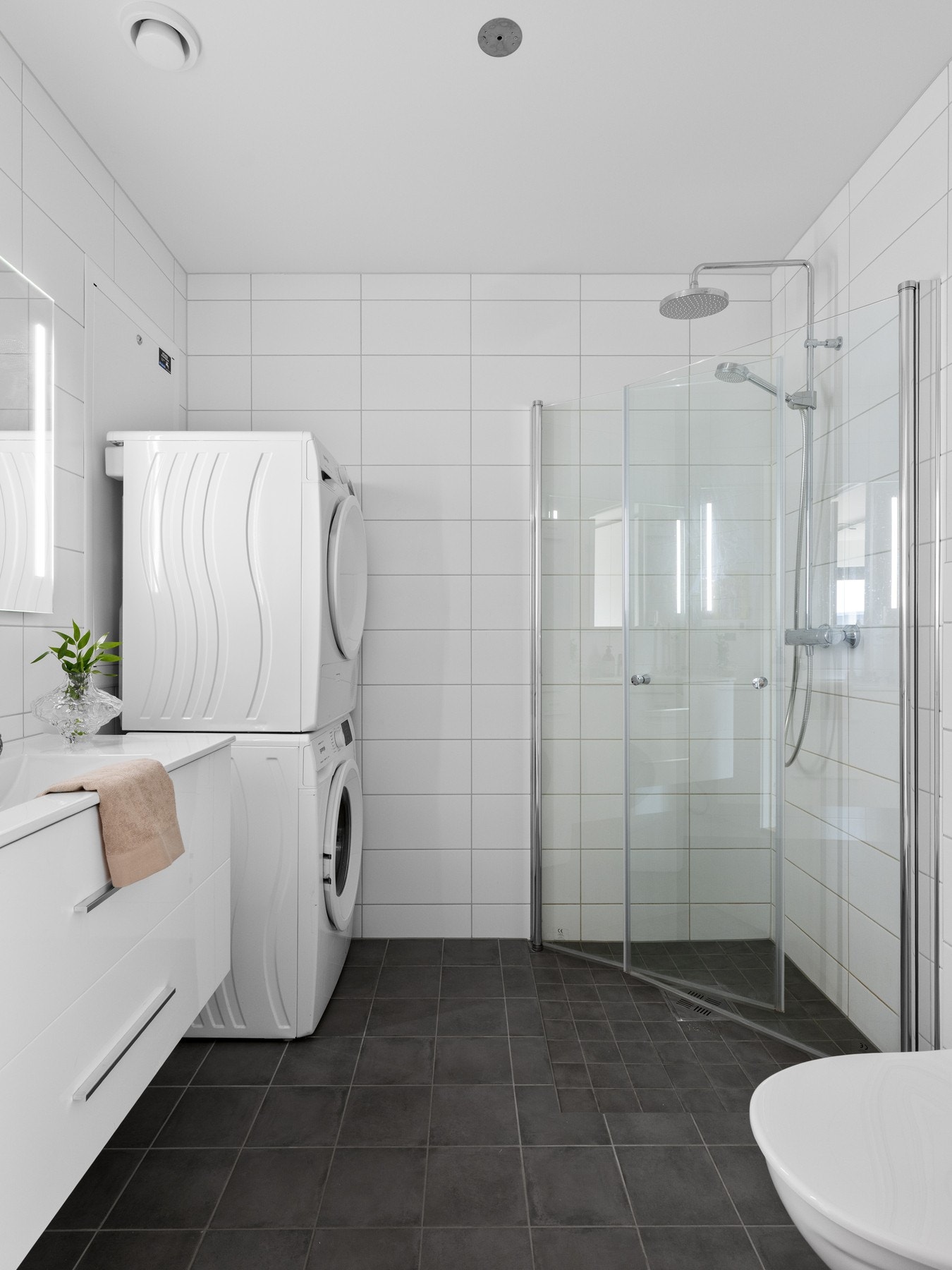 Badet er utstyrt med servant på skuffeseksjon, samt speil med belysning. Videre er badet utstyrt med toalett, innfellbare dusjdører og opplegg til vaskemaskin. Galleribilde