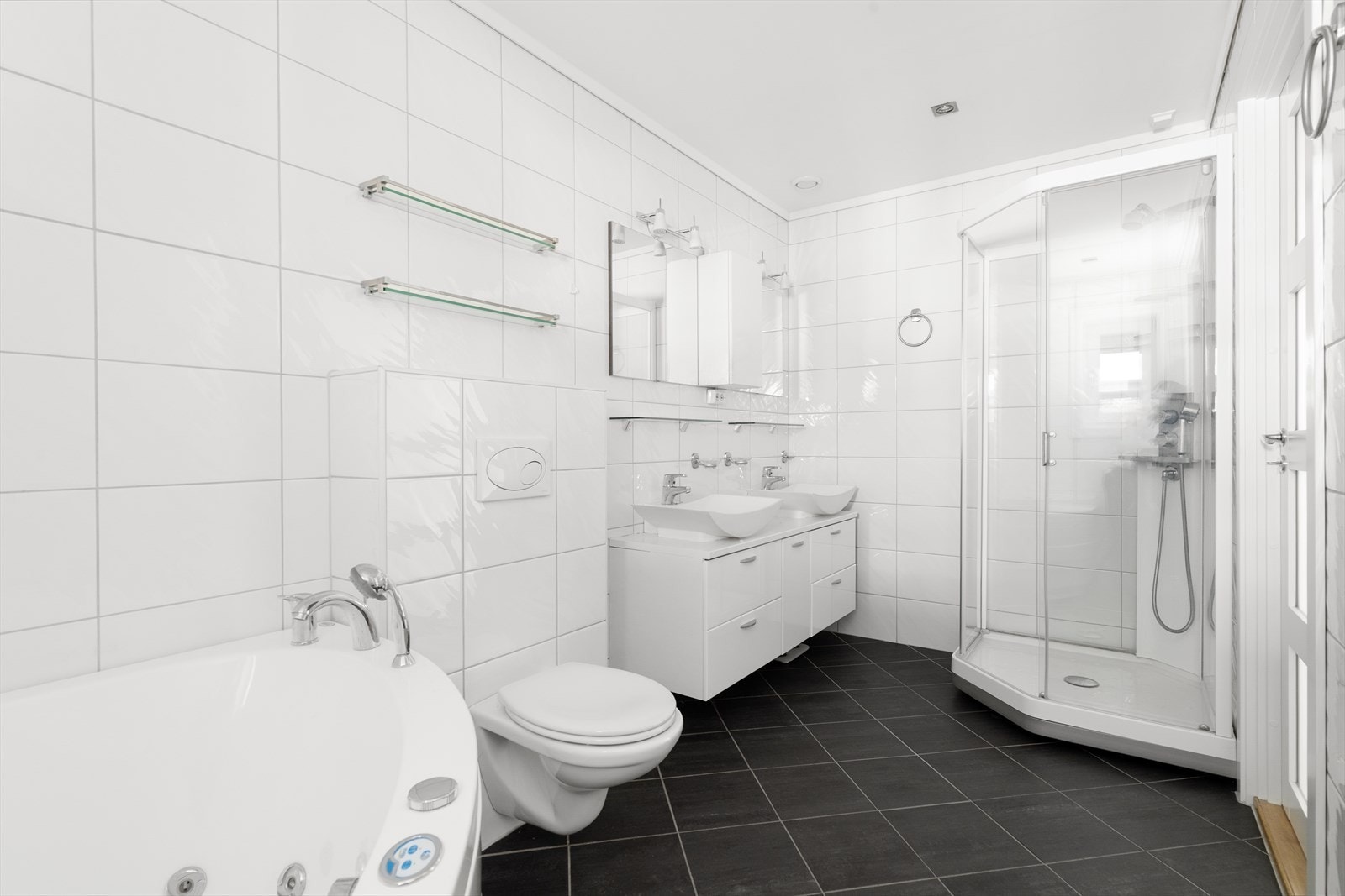 Lyst og delikat baderom med fliser på gulv med varmekabler, flis på vegg og malt himling med downlights. Galleribilde