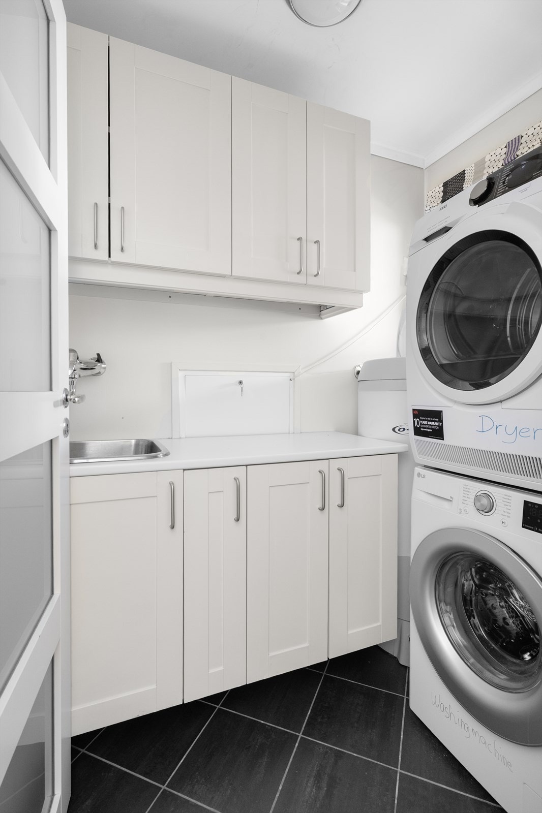 Vaskerommet ligger i praktisk tilknytning med badet og inneholder varmtvannstank på ca. 200l, opplegg til vaskemaskin, rørfordelerskap og innredning med over- og underskap samt skyllekum. Galleribilde