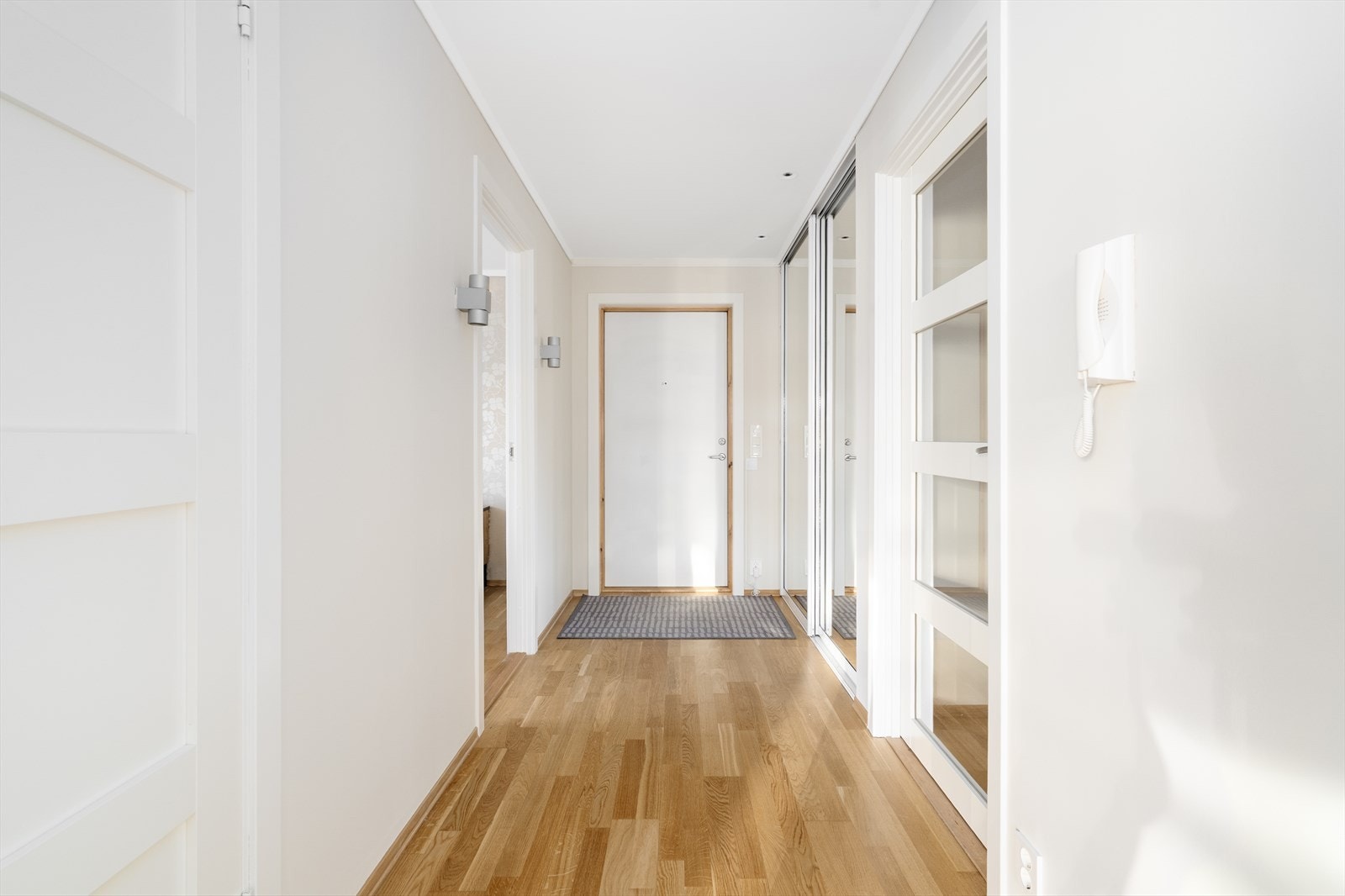 Med enkel adkomst via felles trappegang og heis kommer man inn til en yst og hyggelig entré. Her er det skyvedørsgarderobe med speilfronter som gir god plass til sko- og yttertøy. Galleribilde