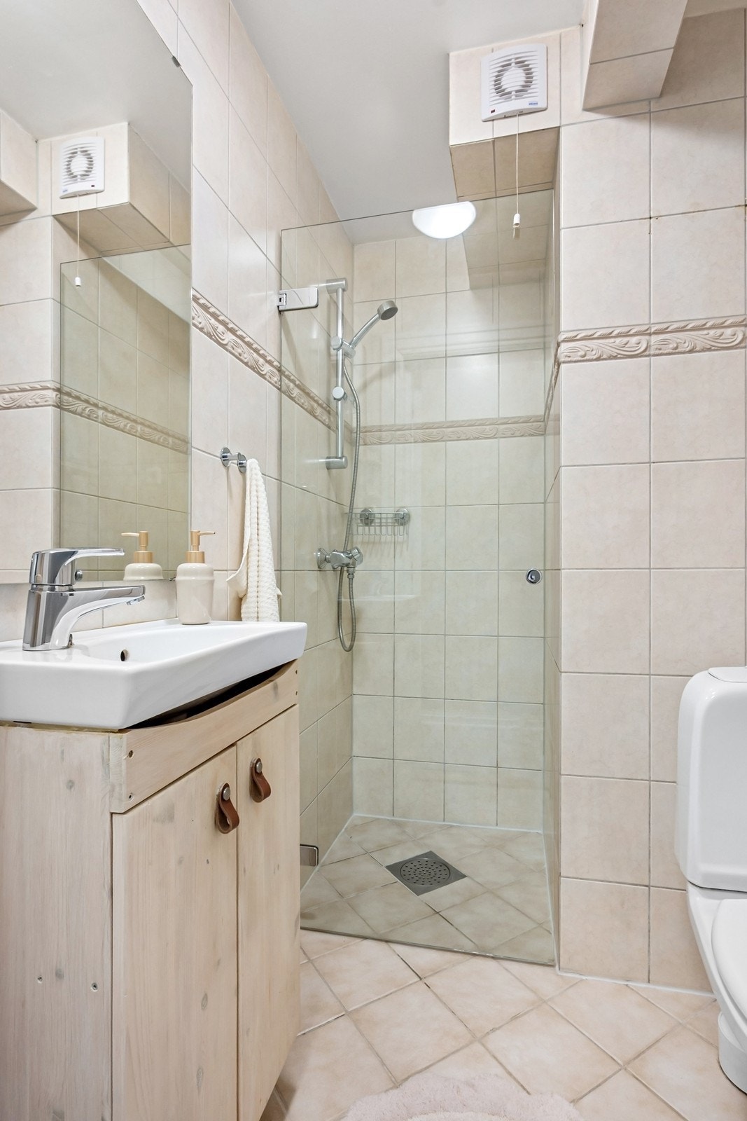 Baderommet er innredet med praktisk dusjnisje, servant og toalett. Galleribilde