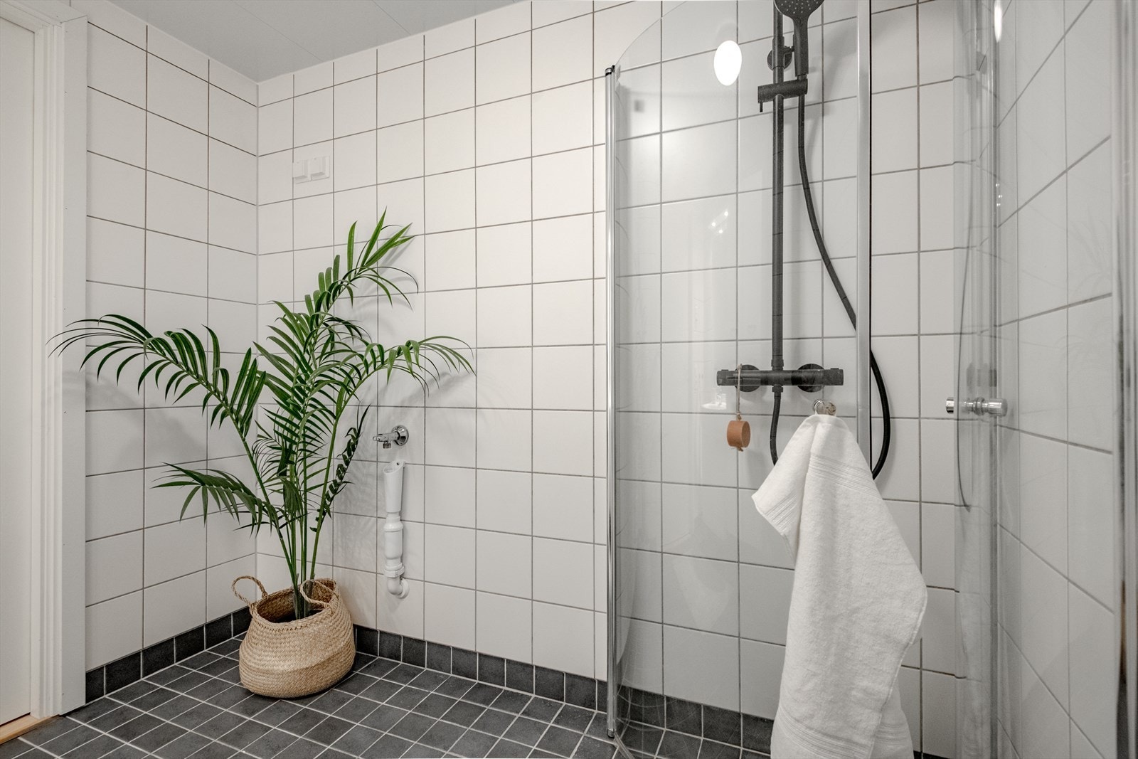 Badet har moderne dusjløsning med glassvegger, god skap- og oppbevaringsplass samt opplegg for vaskemaskin. Galleribilde