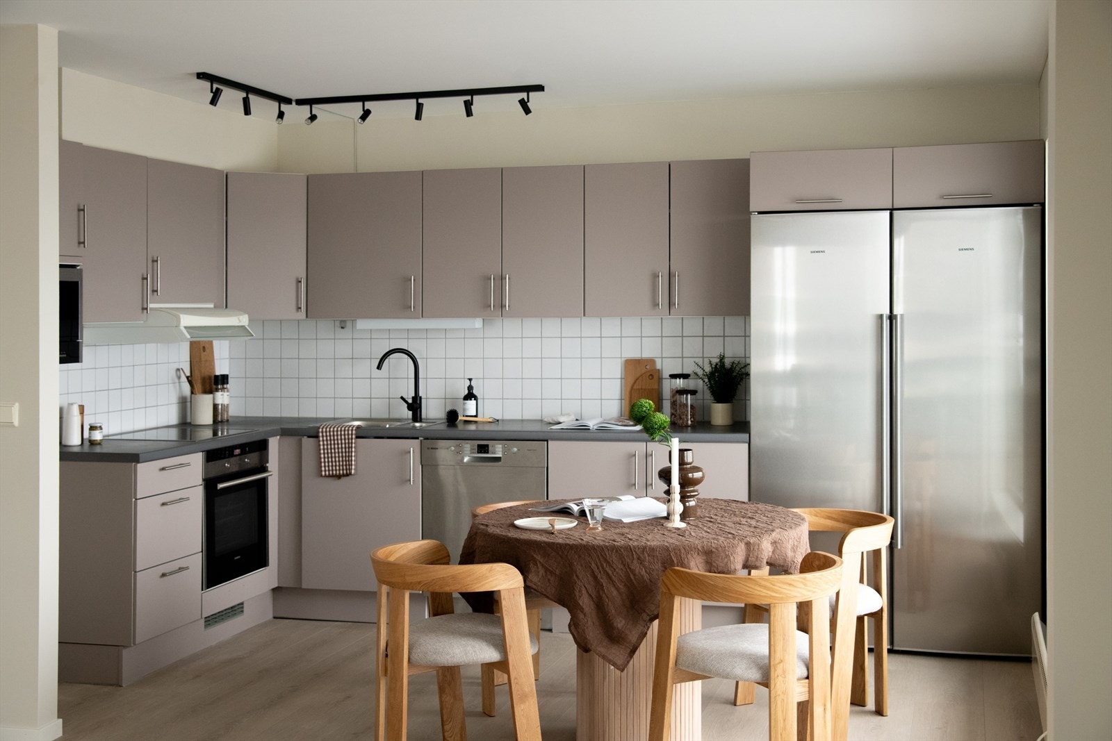 Lyst og moderne kjøkken med slette fronter og med god skap- og benkeplass, samt naturlig spiseplass. Galleribilde