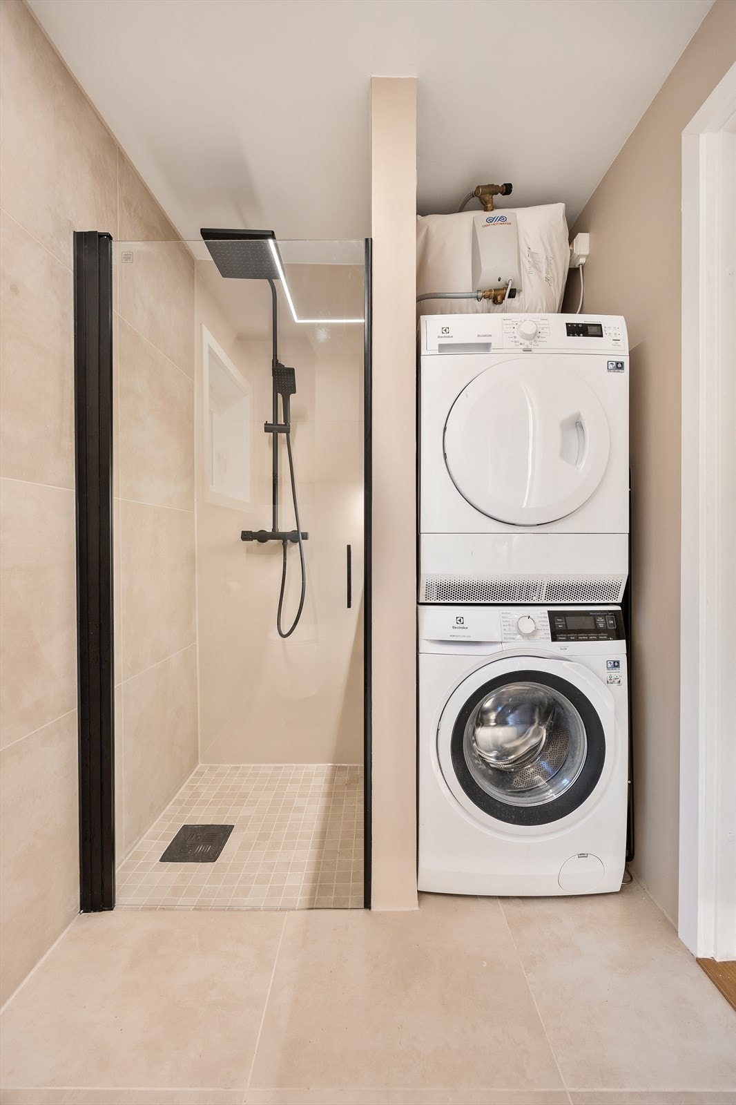 Badet har gulvvarme for ekstra komfort og praktisk opplegg for vaskemaskin Galleribilde