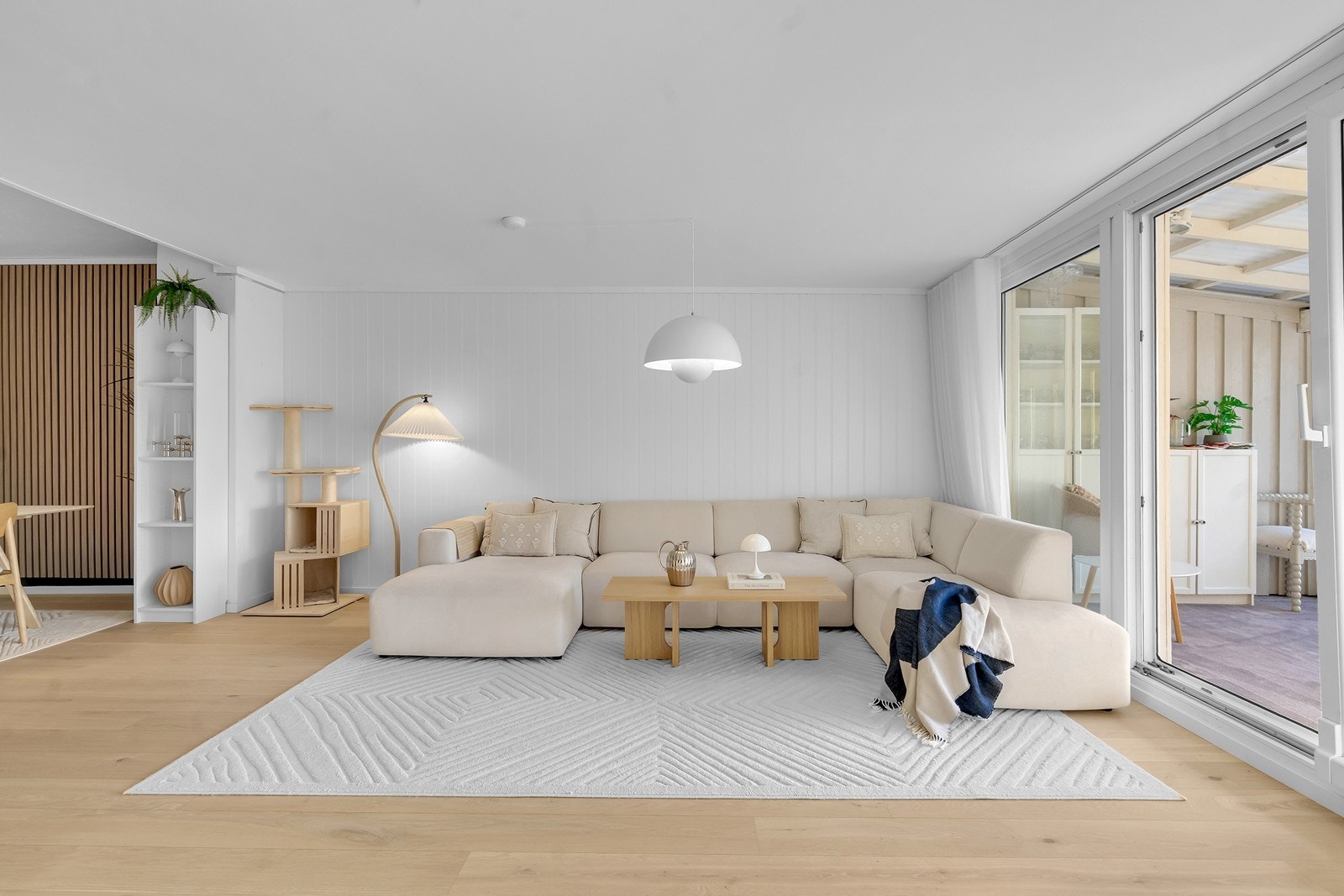 En stor og lys stue med lyse overflater, 1-stavs parkett på gulv og spilevegg Galleribilde