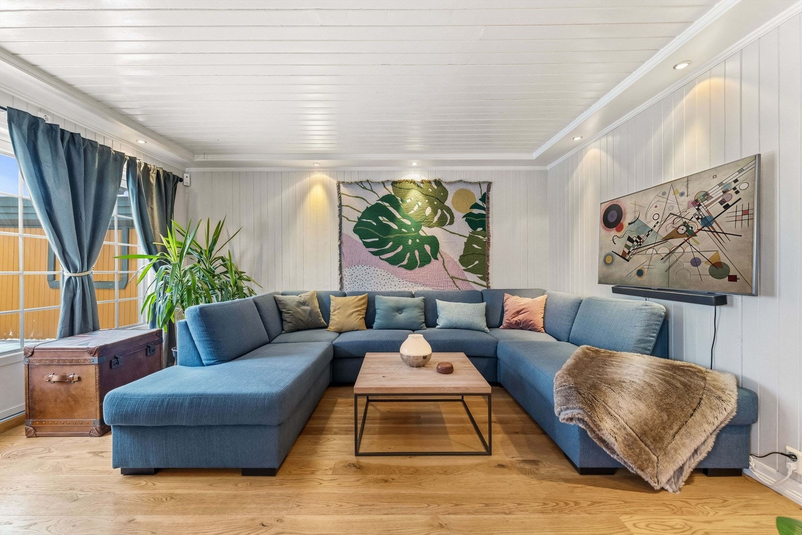 Rommet har enstavs parkett på gulv med gulvvarme, downlights i tak og veggpanel malt i dempede farger. Galleribilde