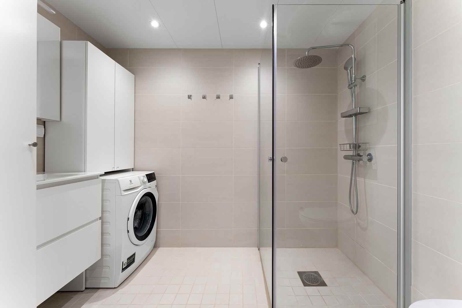 Baderommet fremstår moderne med downlights i tak, opplegg for vaskemaskin og balansert ventilasjon. Galleribilde