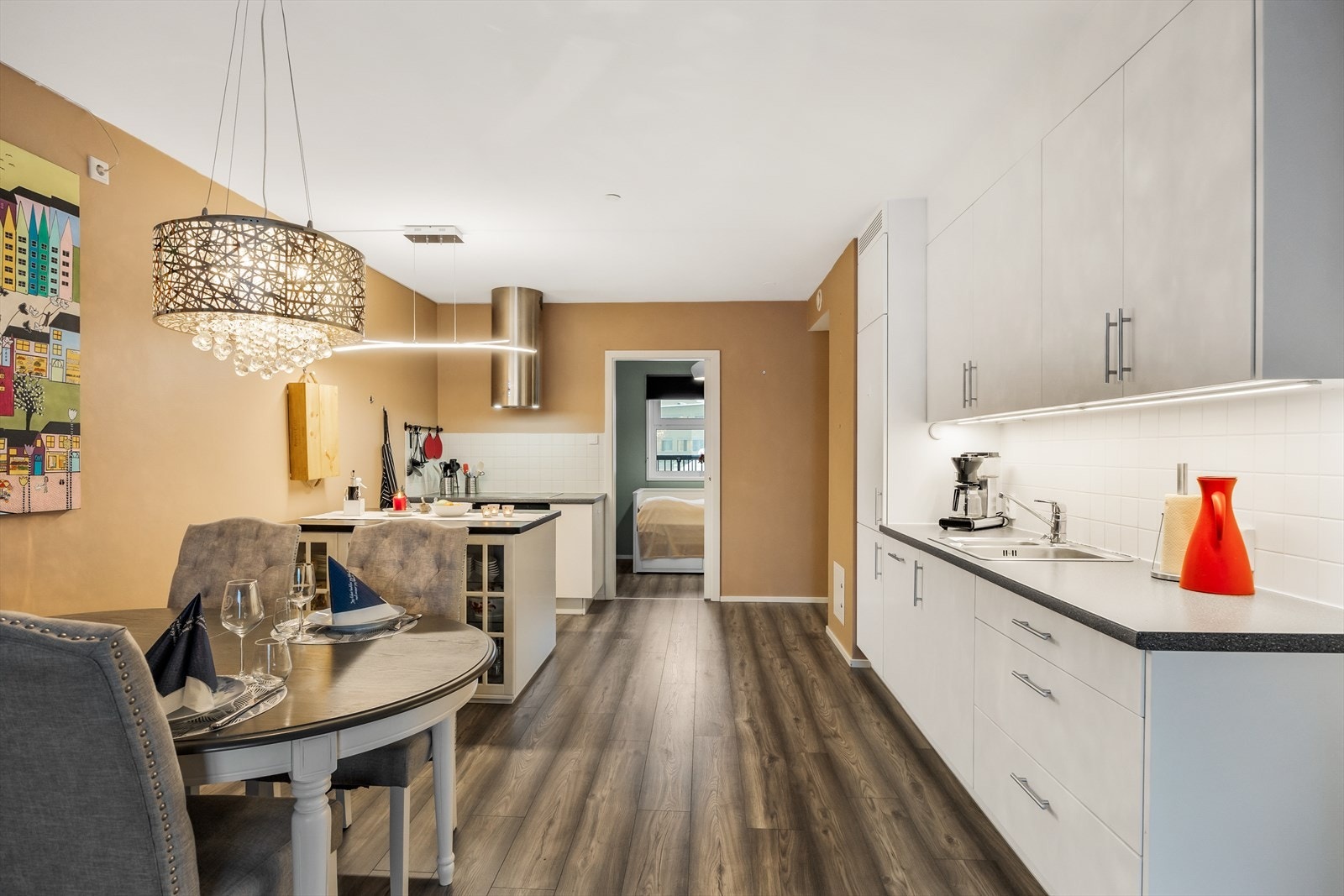 Kjøkkeninnredning med hvite, glatte fronter og laminat benkeplate. Galleribilde