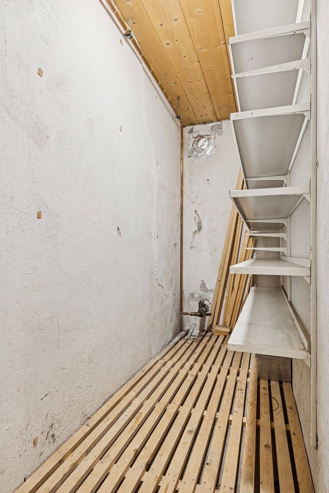 Vegghyller og åpen rørføring gir enkel tilgang til oppbevaring og vannsystem. Galleribilde